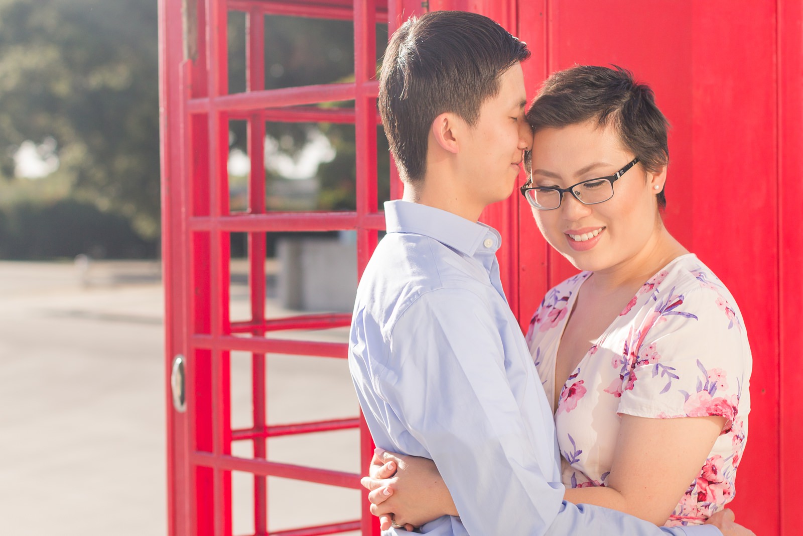 Engaged Couple Pose in Front of Red Telephone Booth by Adrienne and Dani Photography
