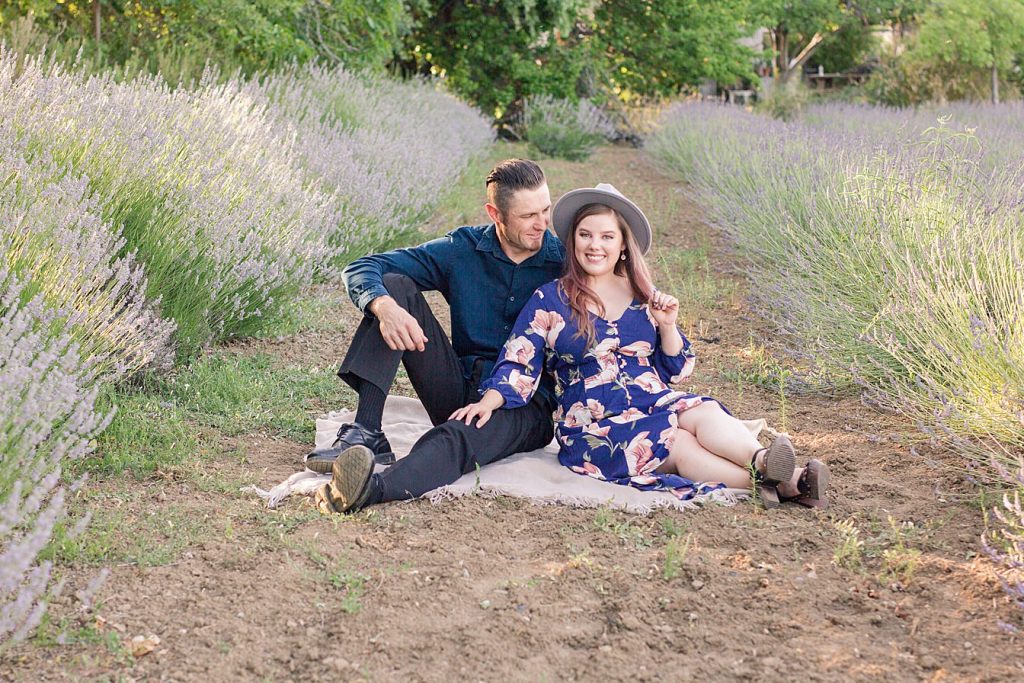 an engaged couple posing in a lavender field by Adrienne and Dani Photography