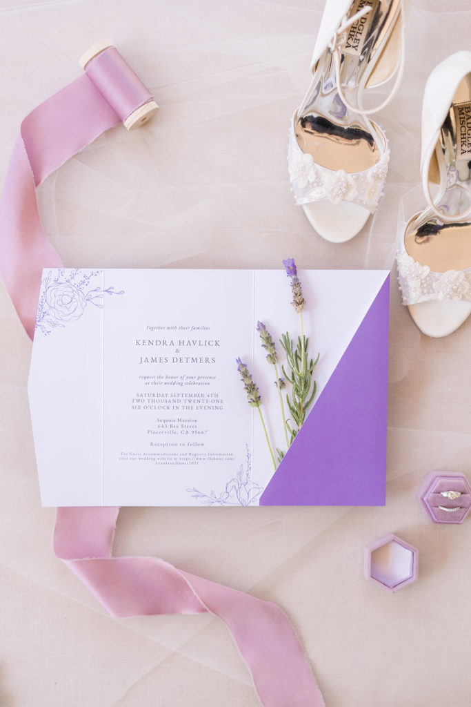 wedding flat lay of wedding invitation suite with badgley mischka shoes