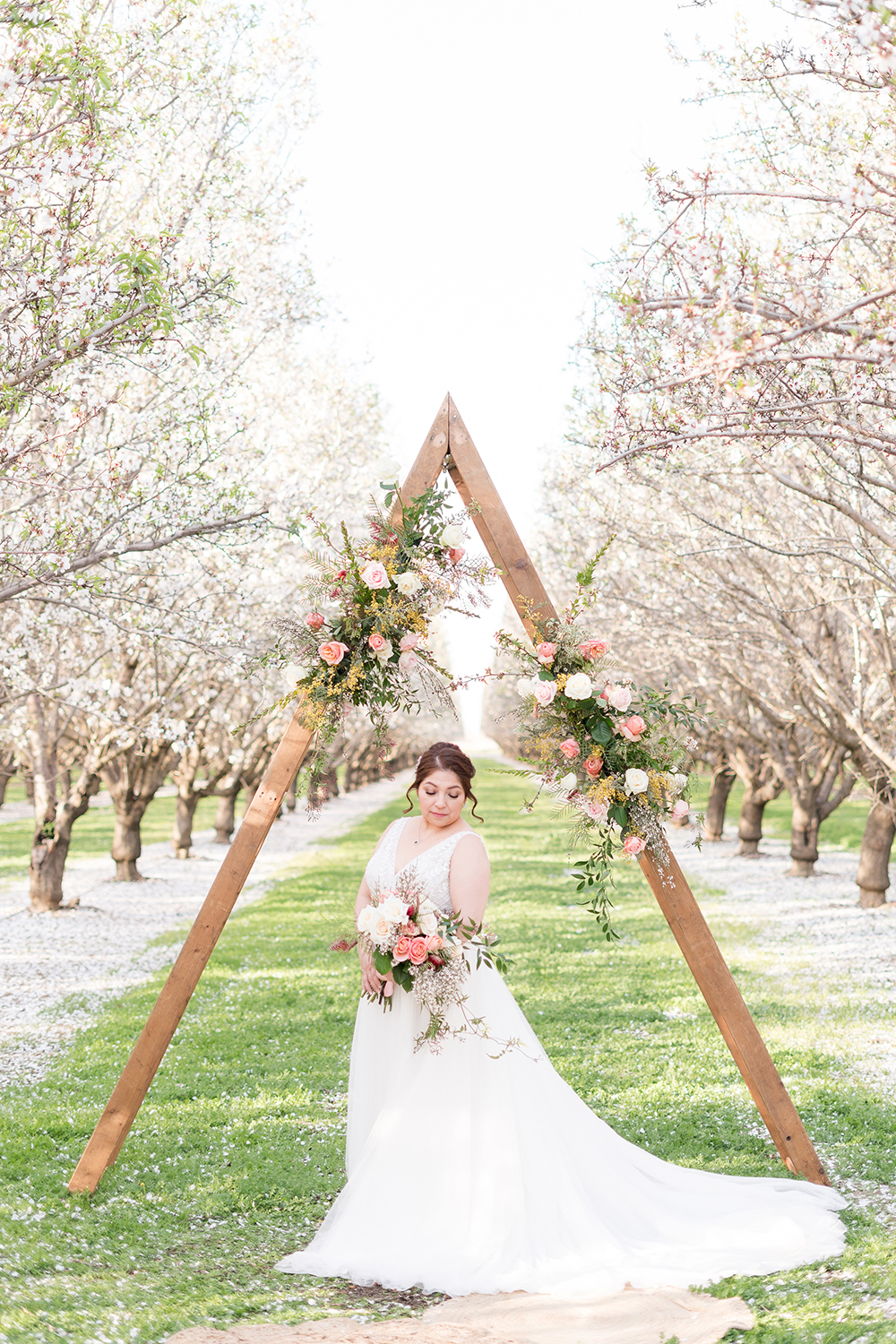 a bride poses under her ceremony arch for her bridal portraits