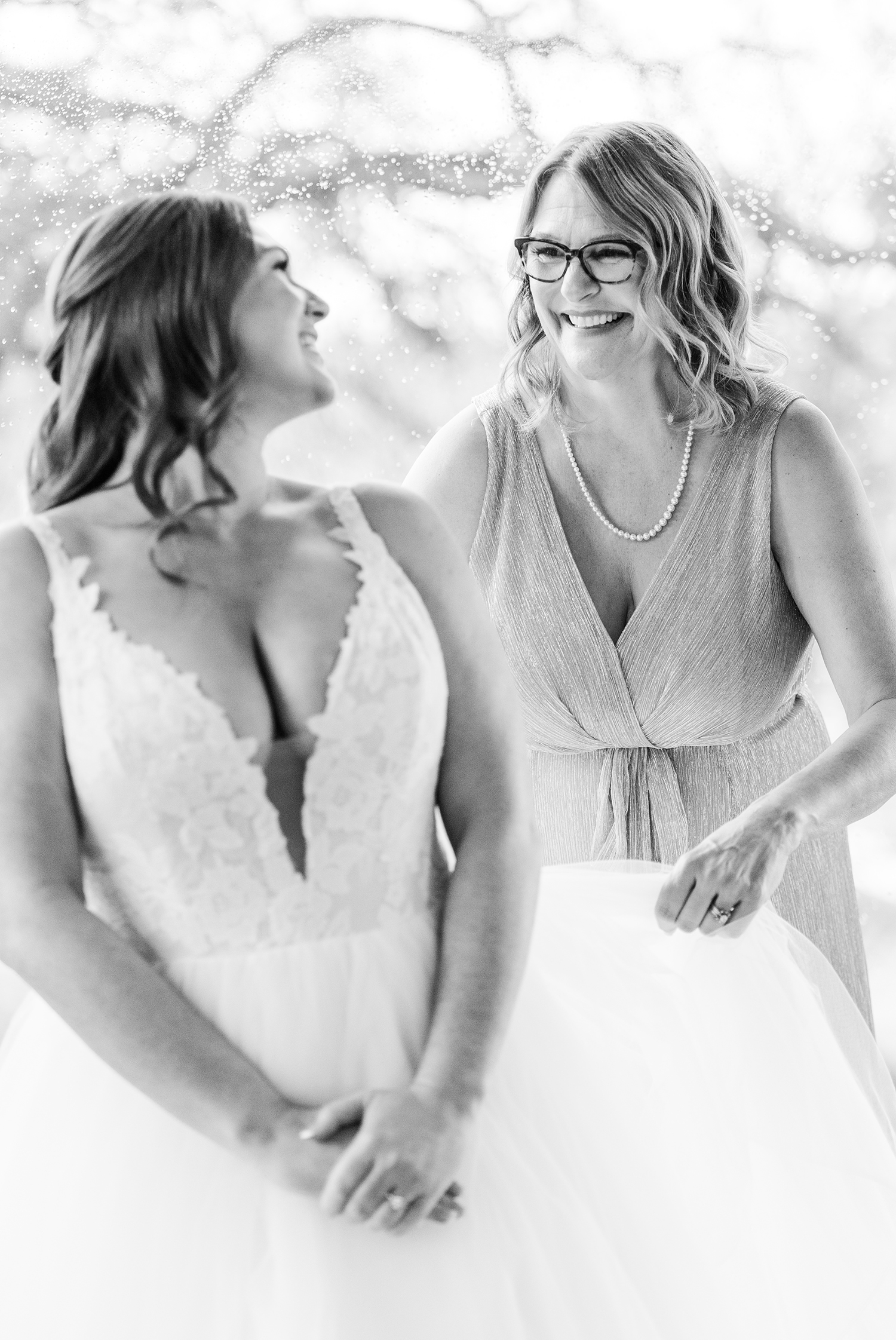 A mother of the bride helping her daughter prepare for her wedding at the Ridge Event Center by Adrienne and Dani Photography