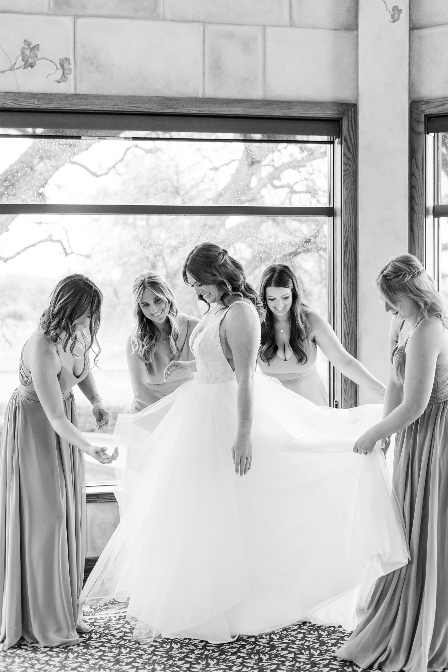 bridesmaids helping the bride prepare for her wedding at the Ridge Event Center by Adrienne and Dani Photography