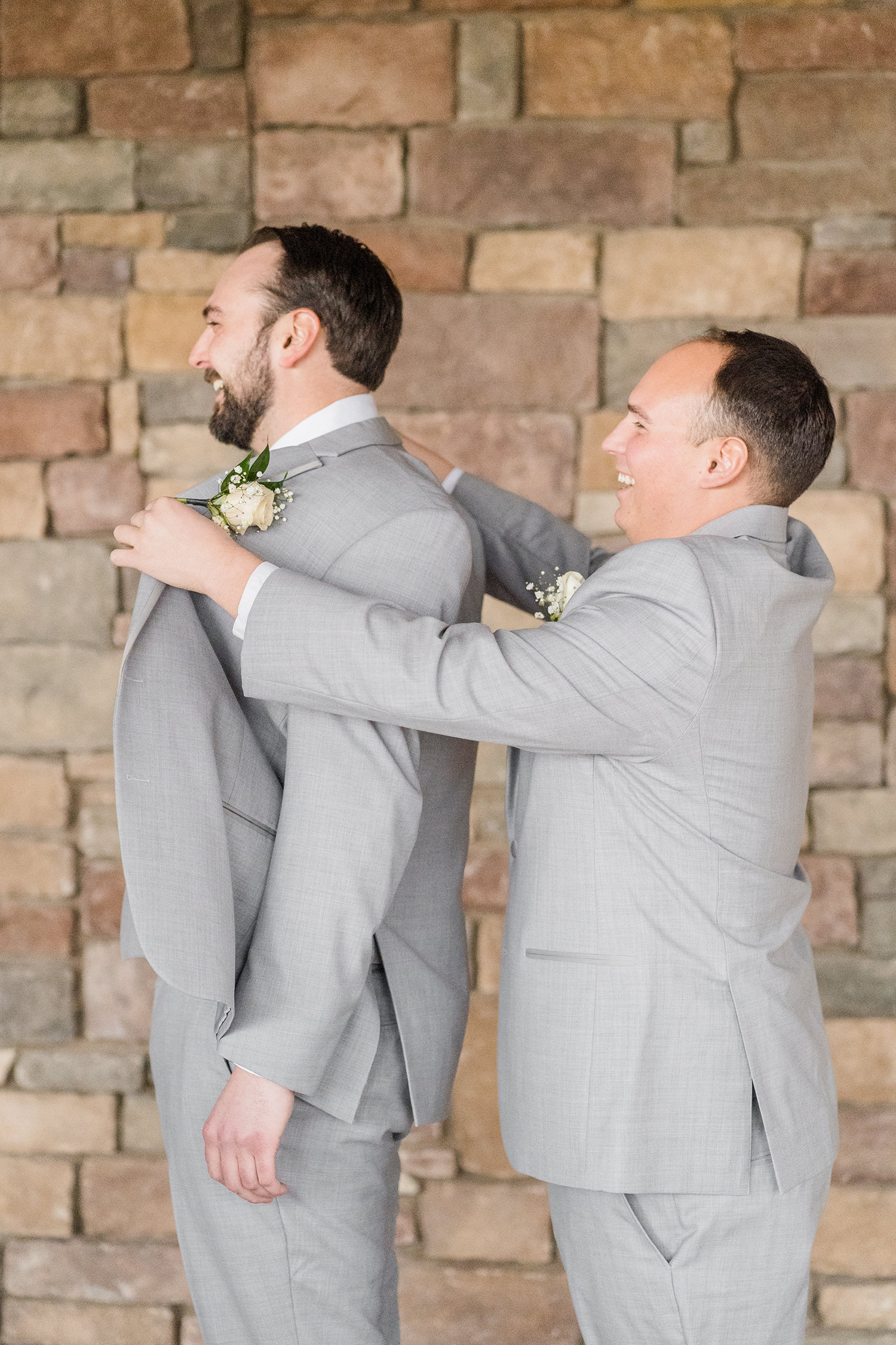 a grooms brother helping him prepare for his wedding at the Ridge Event Center by Adrienne and Dani Photography