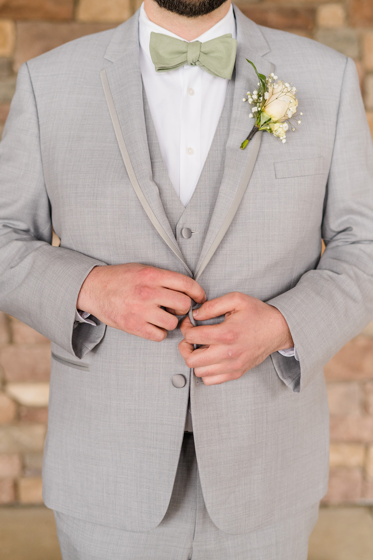 a groom preparing for his wedding at the Ridge Event Center by Adrienne and Dani Photography