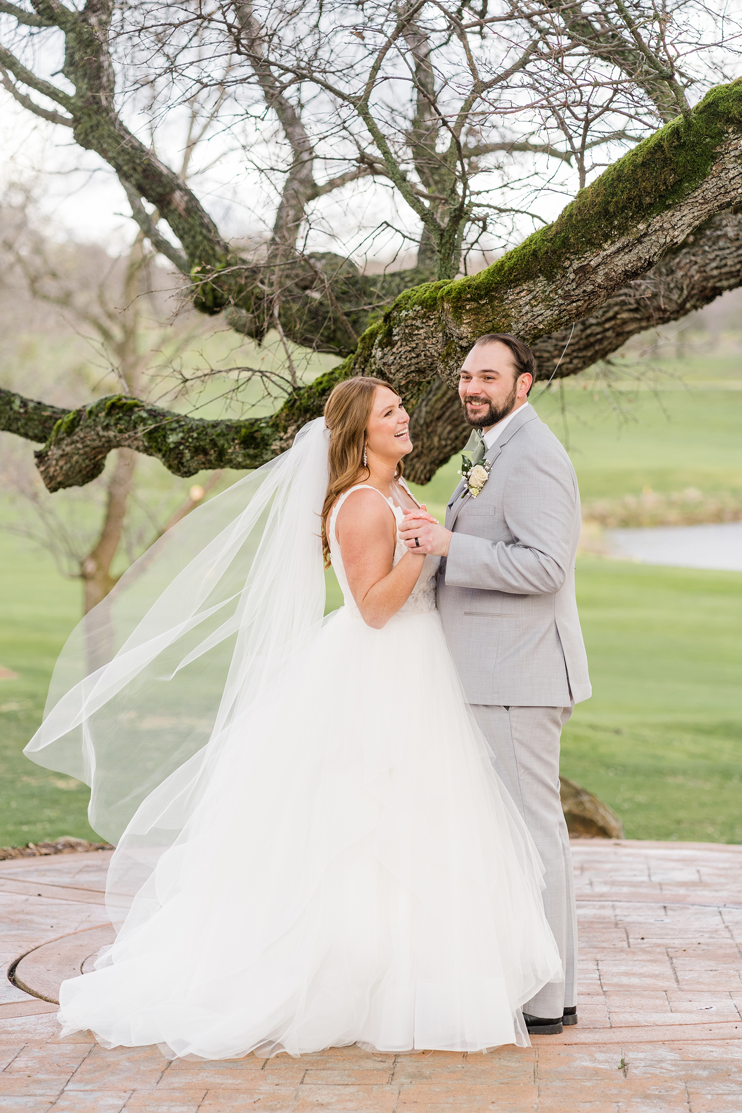 a bride and groom pose for their formal portraits at the Ridge Event Center by Adrienne and Dani Photography
