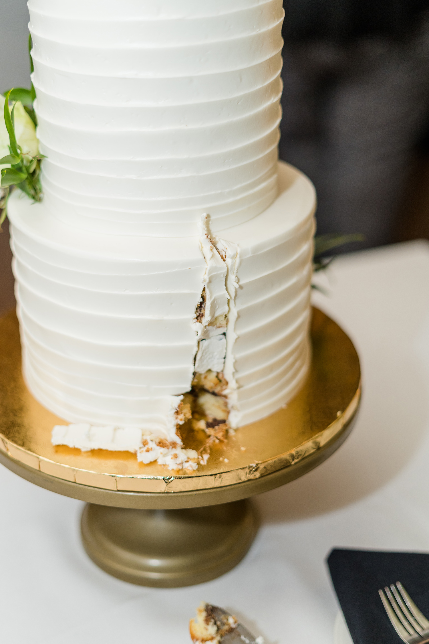 a bride and groom cut their wedding cake at the Ridge Event Center by Adrienne and Dani Photography