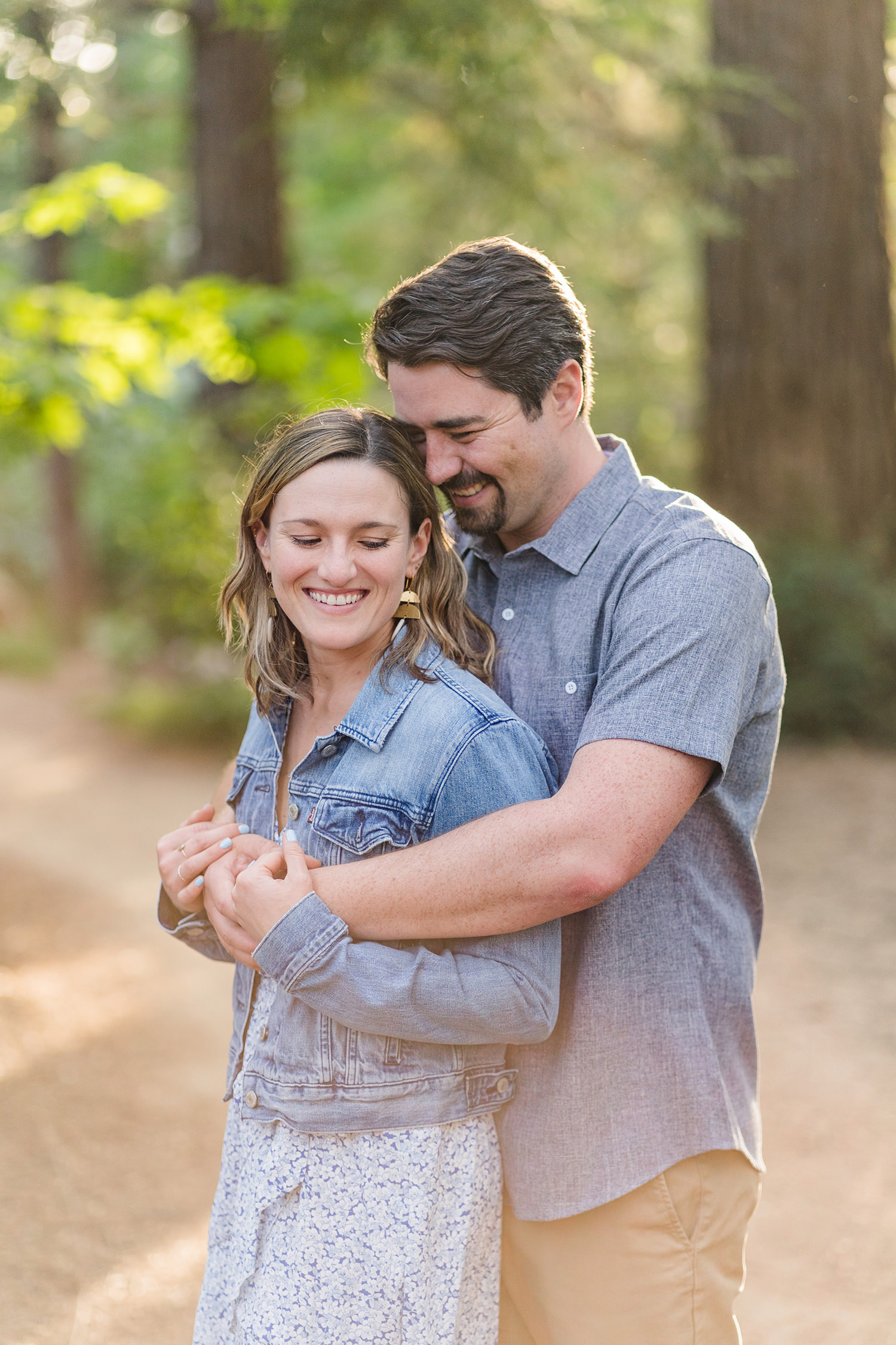 an engaged couple embrace during their uc davis arboretum engagement session in the redwood grove