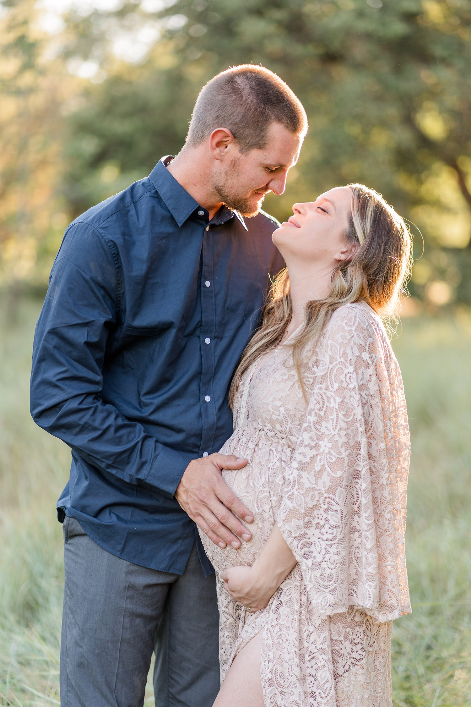 soon to be mother poses with her husband for her UC Davis Arboretum Maternity Portraits by adrienne and dani photography