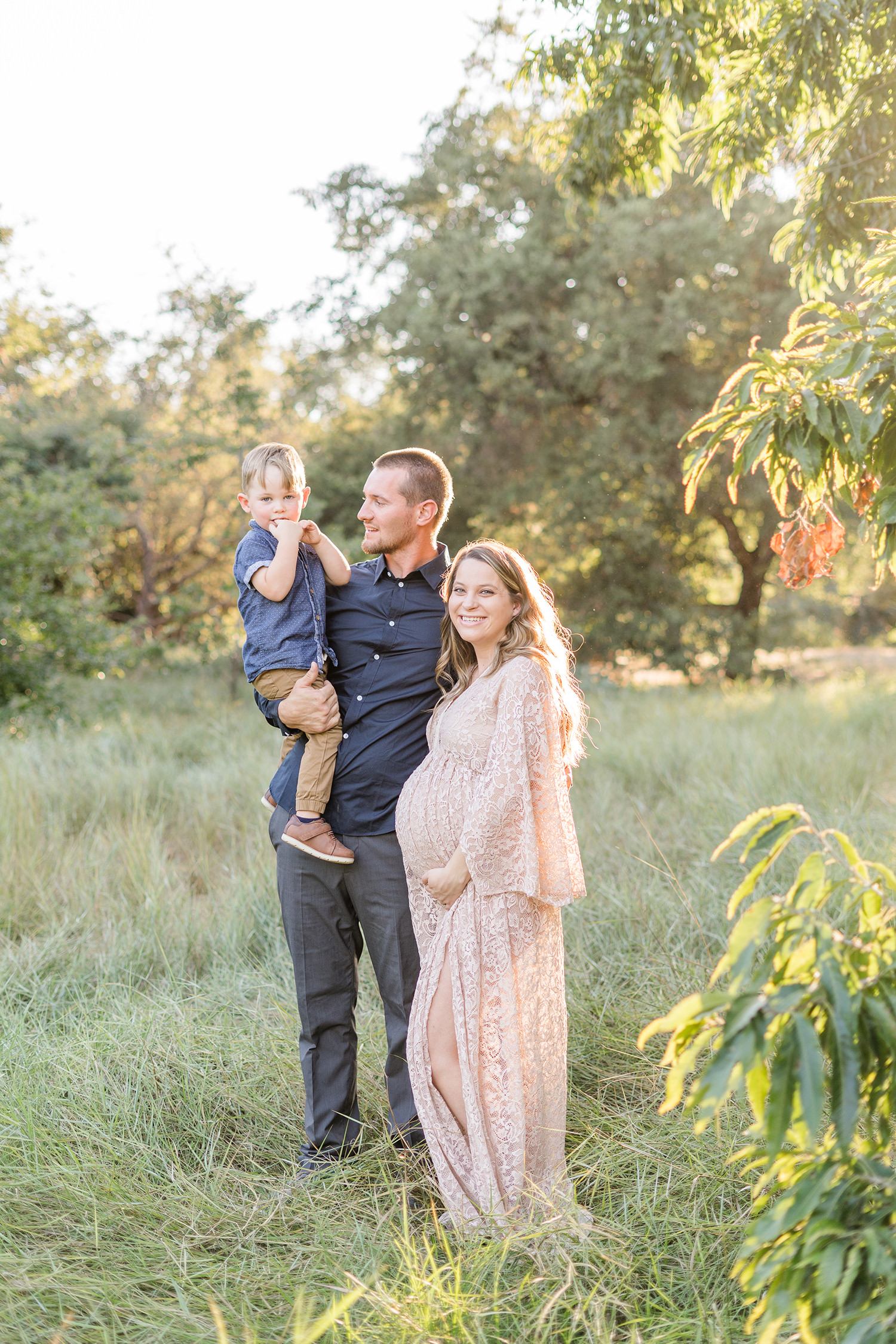 soon to be mother poses with her family for her UC Davis Arboretum Maternity Portraits by adrienne and dani photography