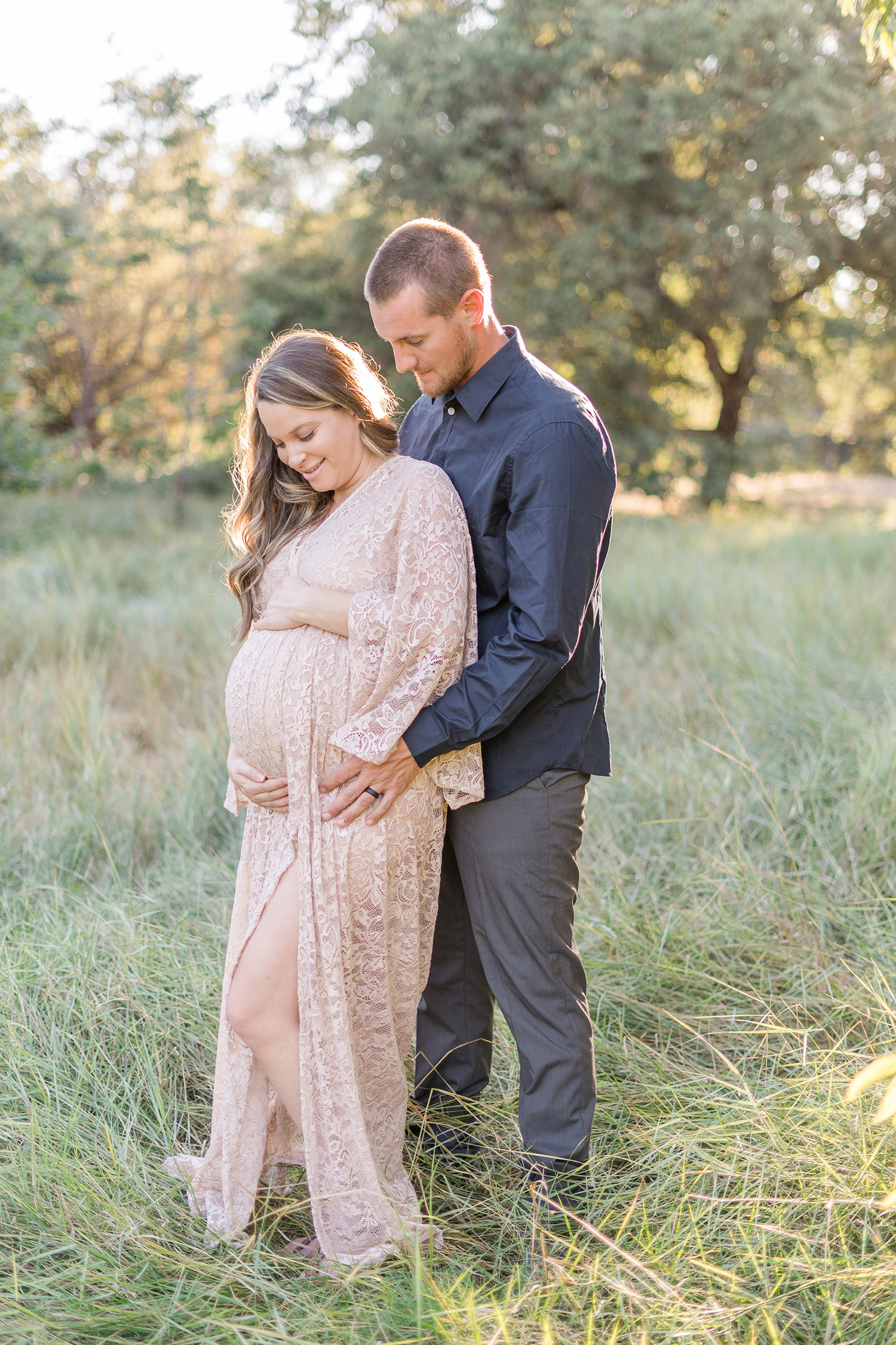 soon to be mother poses with her husband for her UC Davis Arboretum Maternity Portraits by adrienne and dani photography