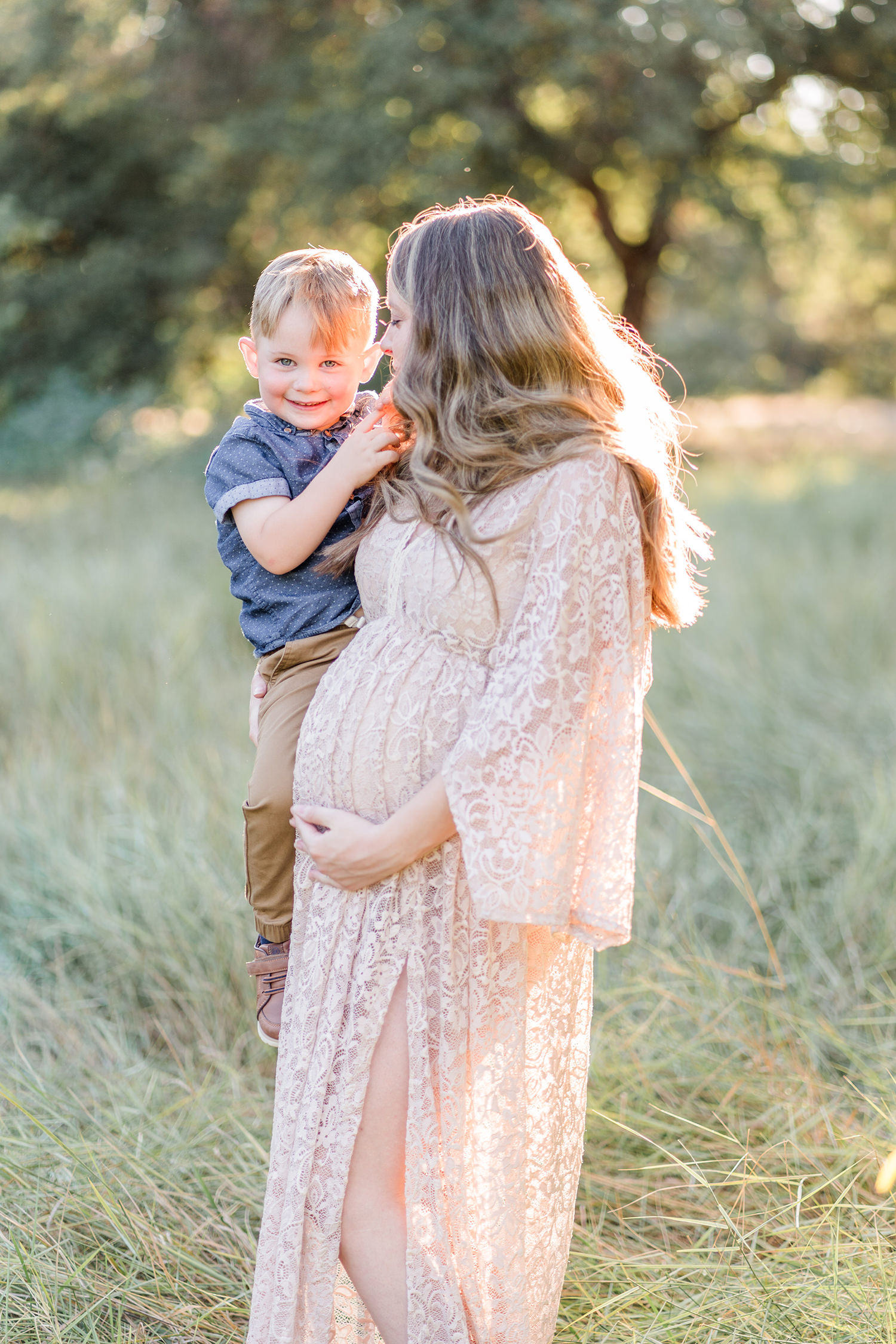 soon to be mother poses with her son for her UC Davis Arboretum Maternity Portraits by adrienne and dani photography