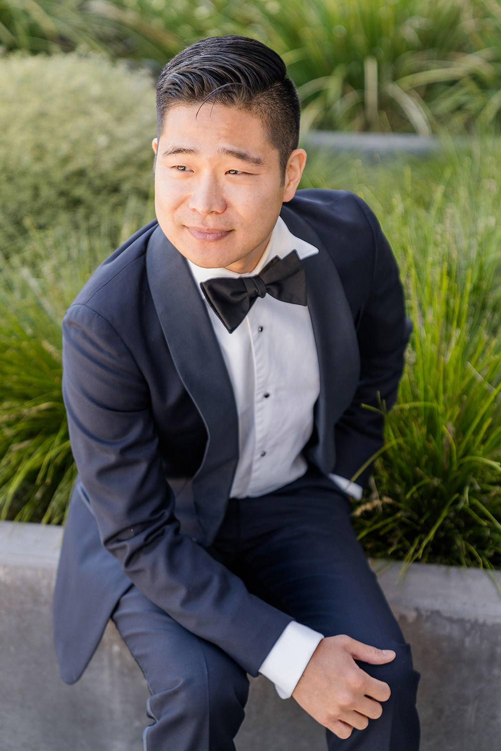 a groom sits posing for a portrait at his Piedmont Park Wedding