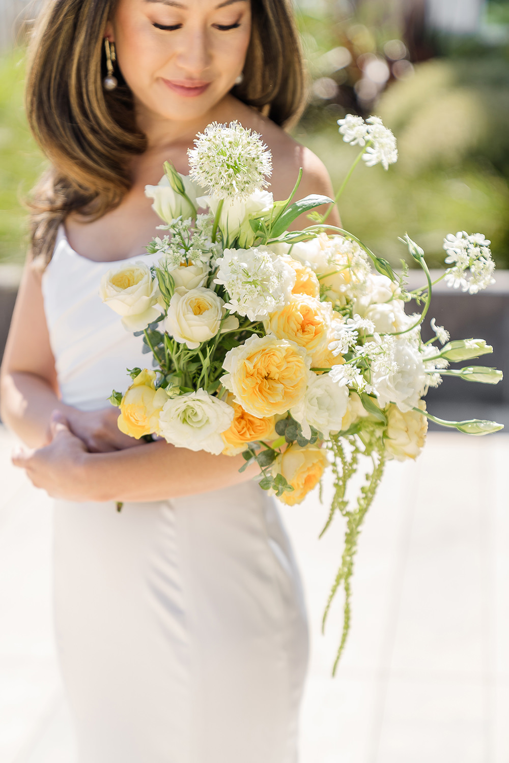 a bride poses holding her bouquet for a portrait at her Piedmont Park Wedding