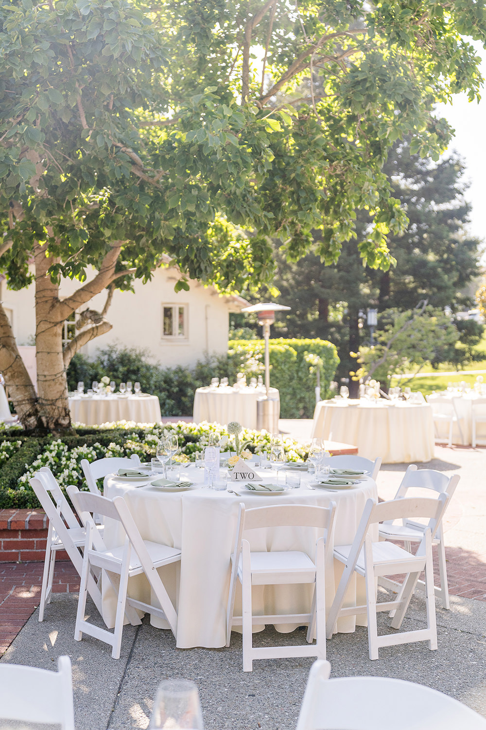 a reception table set up with white and sage green table linens at a Piedmont Park Wedding