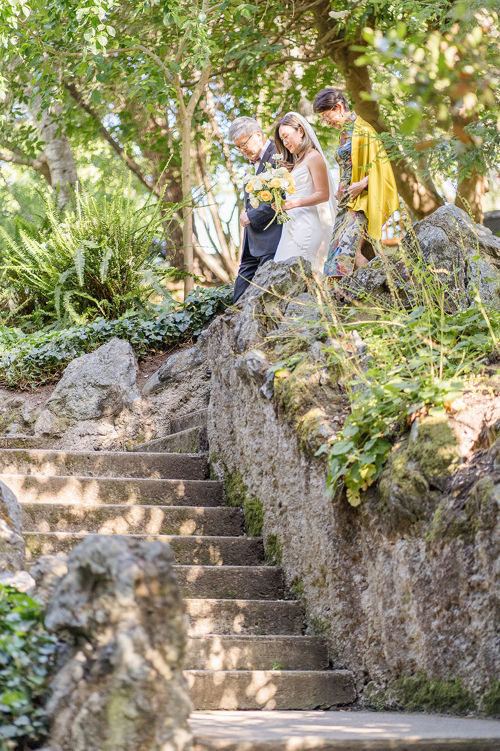 a bride walks down the aisle with her parents at her Piedmont Park Wedding