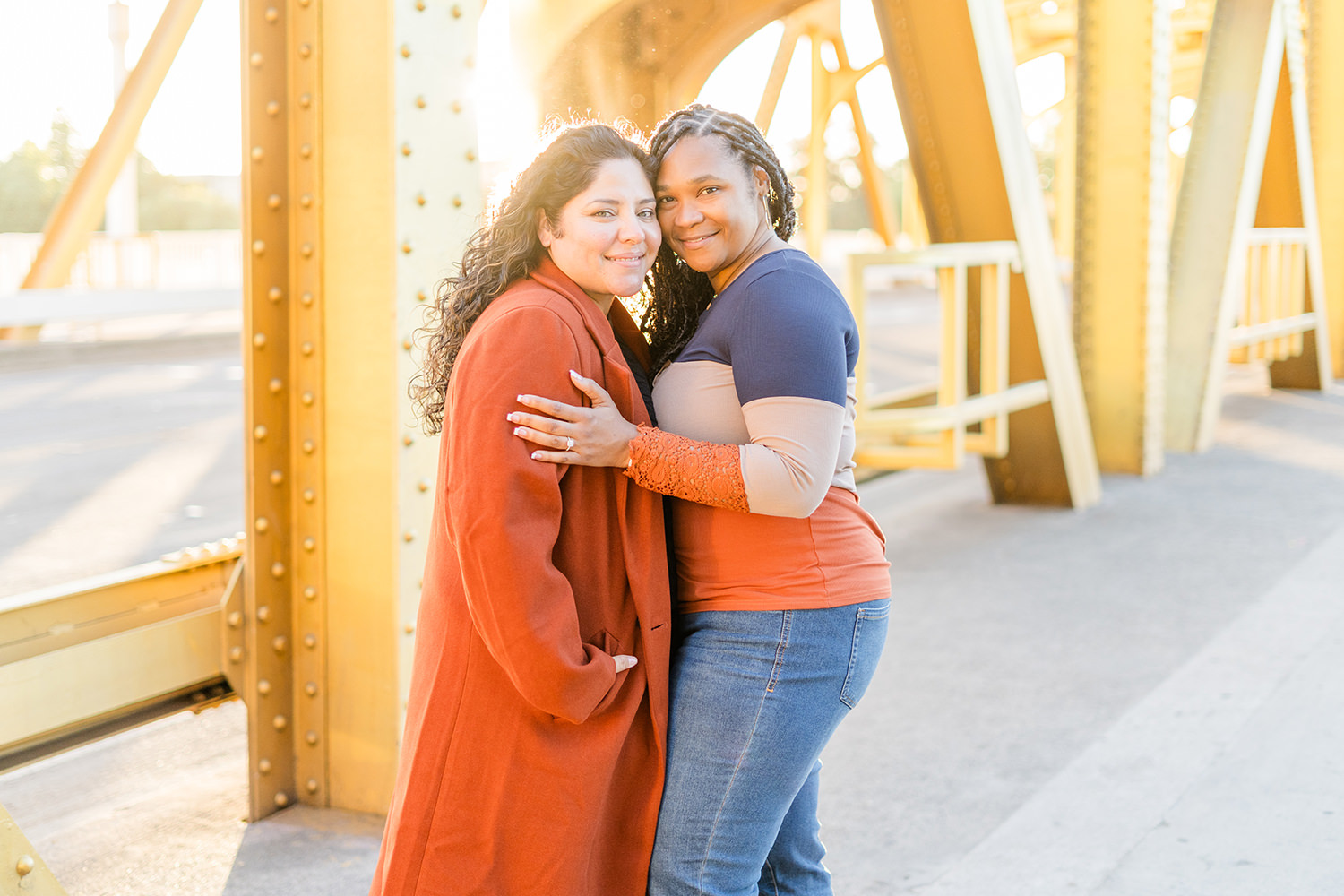 a lgbt lesbian couple snuggle up and laugh at their Downtown Sacramento LGBT Engagement Photos