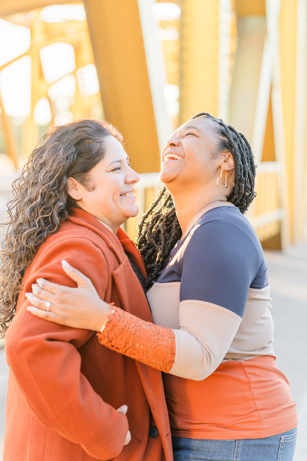 a lgbt lesbian couple share a laugh at their Downtown Sacramento LGBT Engagement Photos