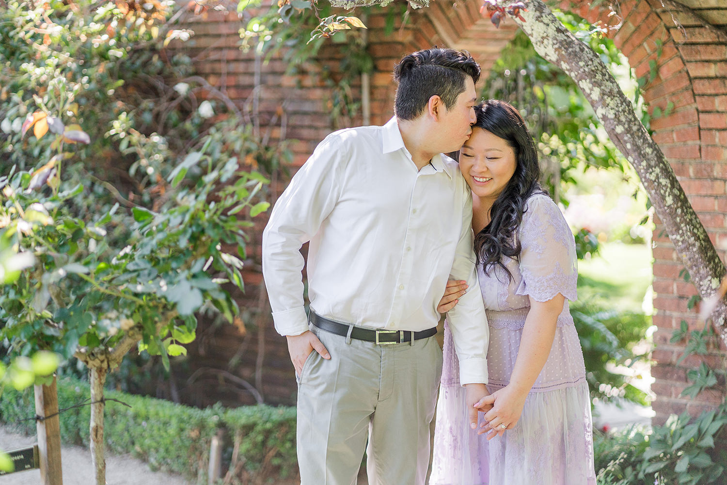 a bride and groom to be snuggle up together during their filoli gardens engagement photos.