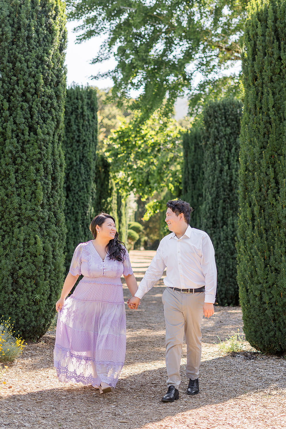 a bride and groom to be walk holding hands during their filoli gardens engagement photos.