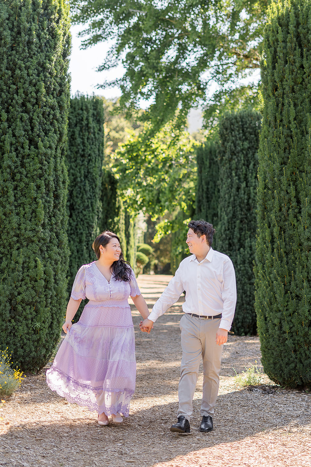 a bride and groom to be walk holding hands during their filoli gardens engagement photos.