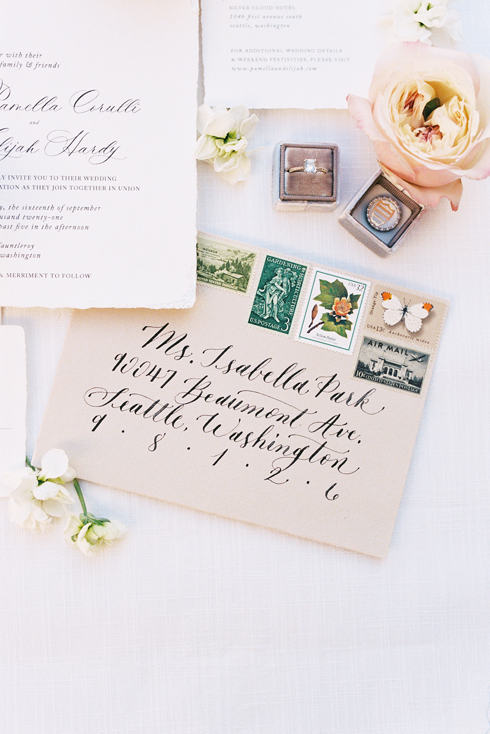 A wedding invitation envelope featuring hand script calligraphy surrounded by bridal details photographed on Kodak Portra 400 Film 