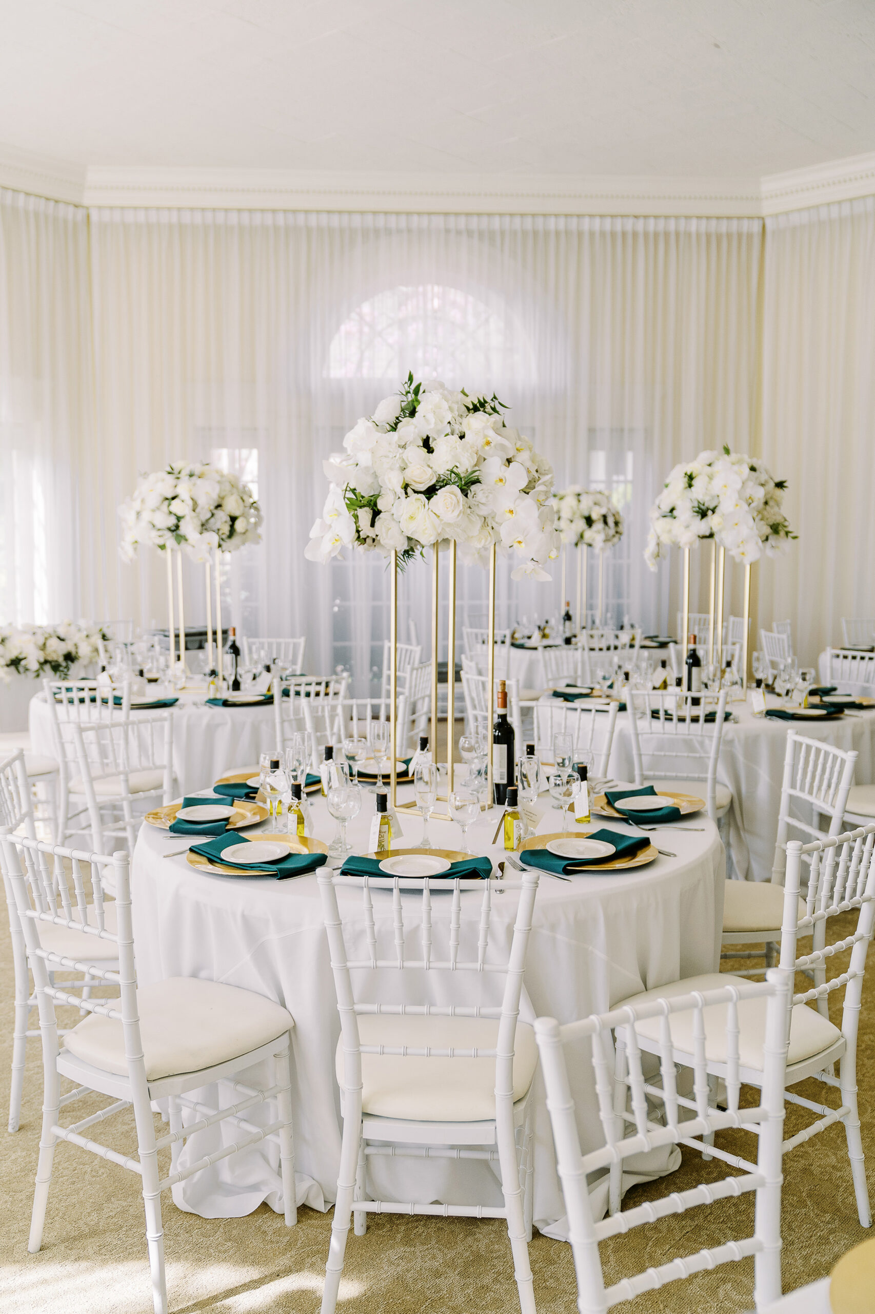 a reception set up for a Downtown Sacramento Vizcaya Wedding featuring tall centerpieces of white florals