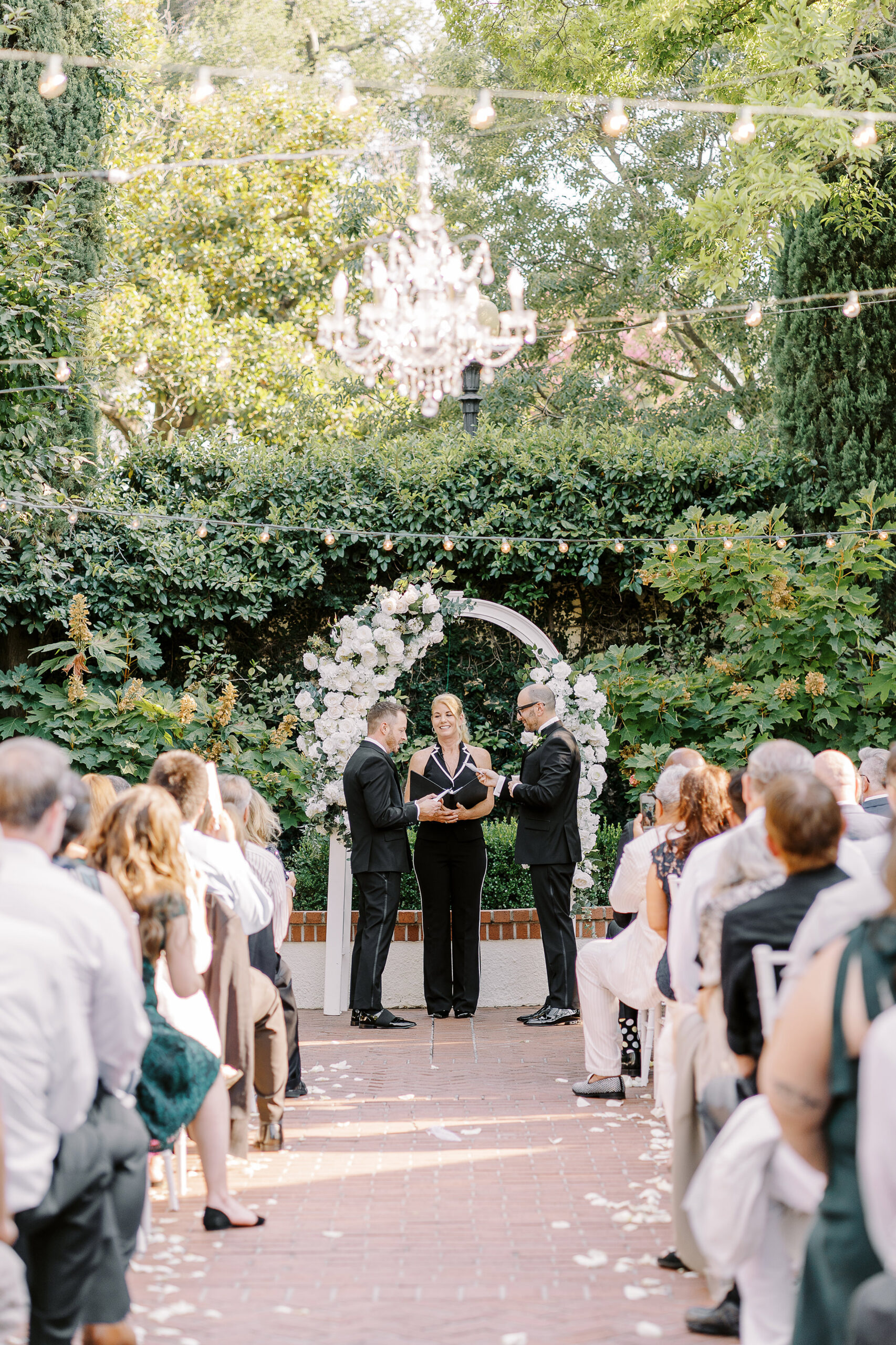 two grooms hold hands during their wedding ceremony at their Downtown Sacramento Vizcaya Wedding 
