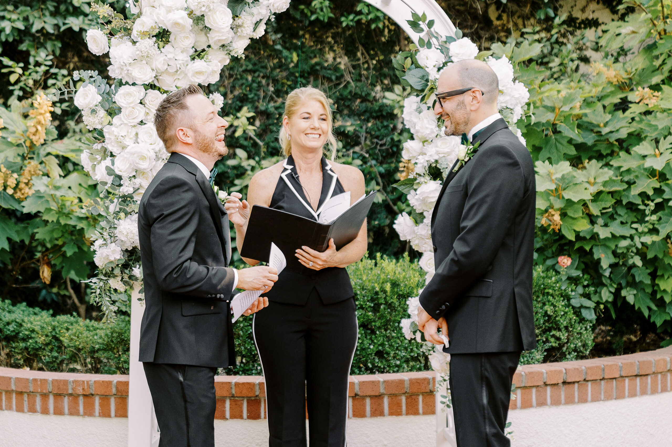 two grooms read their vows and laugh during their wedding ceremony at their Downtown Sacramento Vizcaya Wedding 