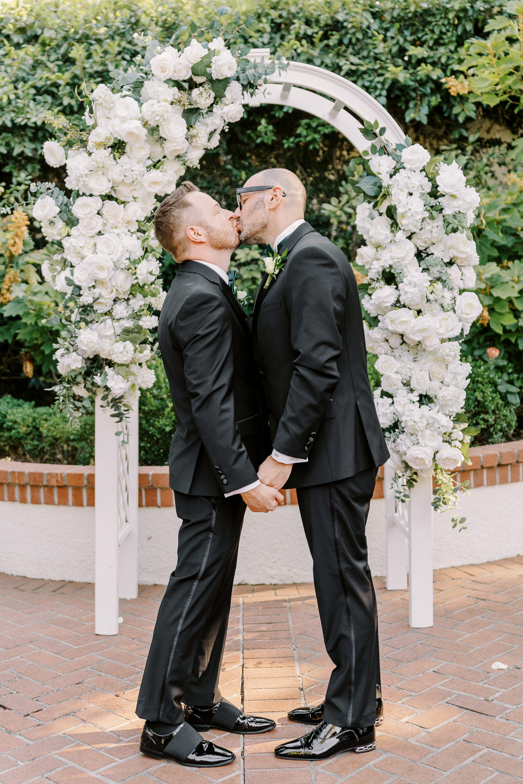 two grooms share their first kiss during their wedding ceremony at their Downtown Sacramento Vizcaya Wedding 