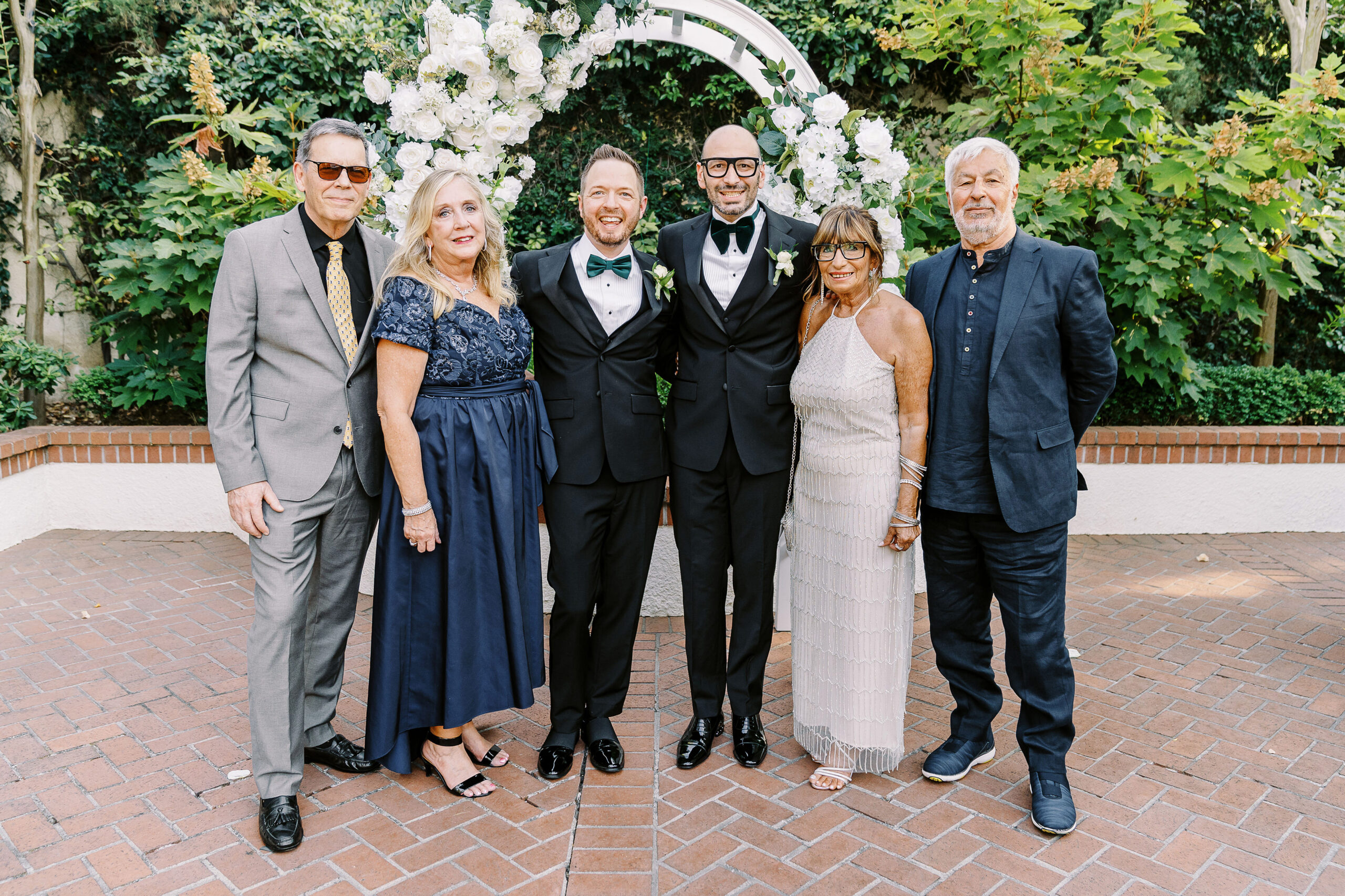 two groom pose with their parents at their Downtown Sacramento Vizcaya Wedding 