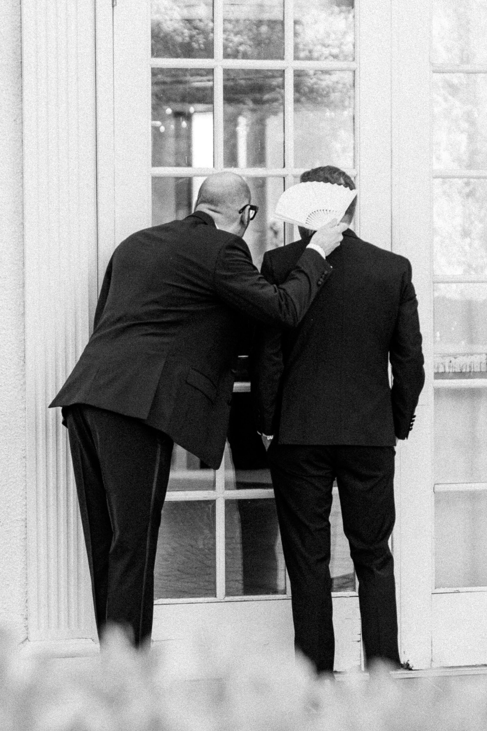 two groom sneak a peek at their reception space at their Downtown Sacramento Vizcaya Wedding 