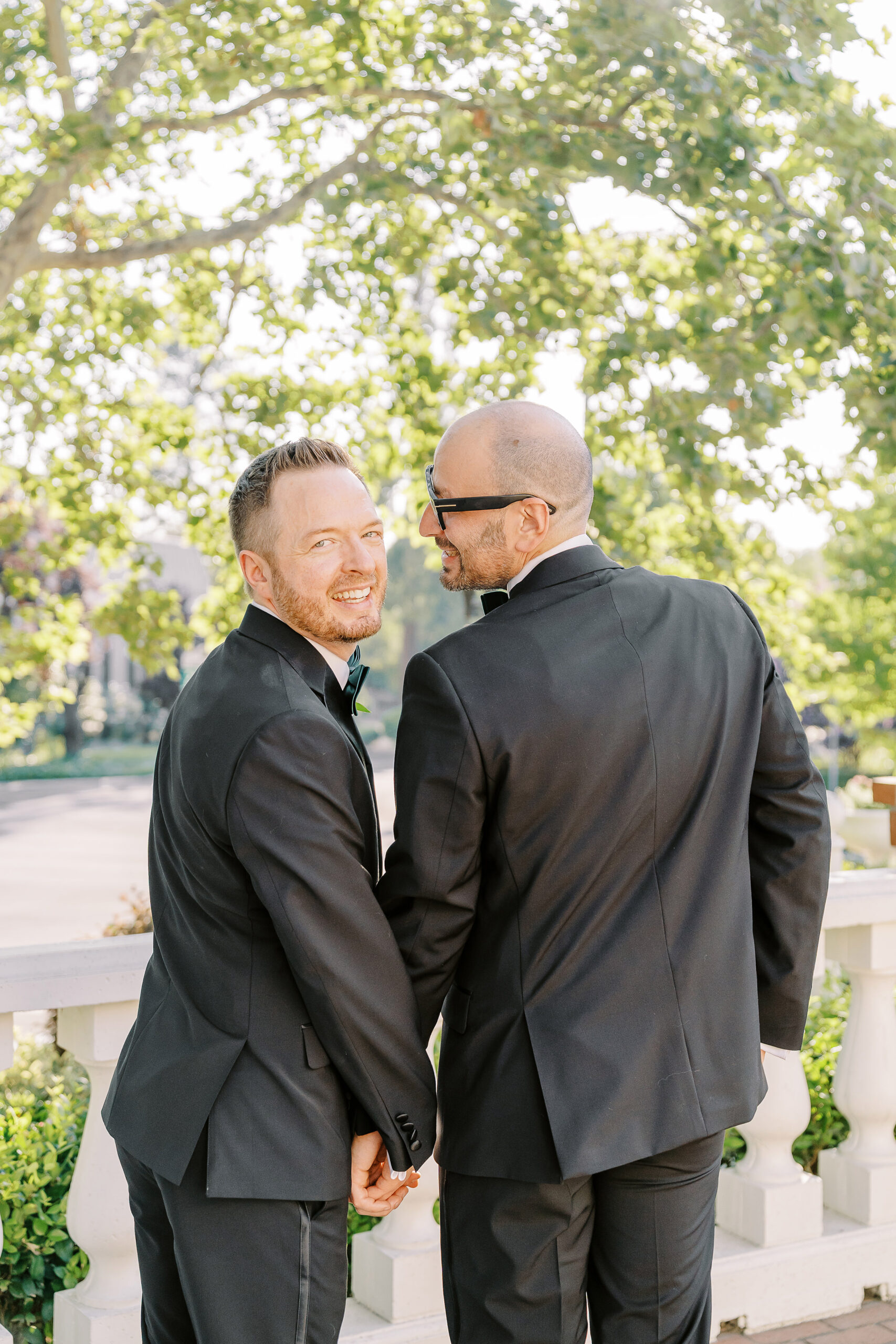two grooms embrace each other and hold hands at their Downtown Sacramento Vizcaya Wedding 