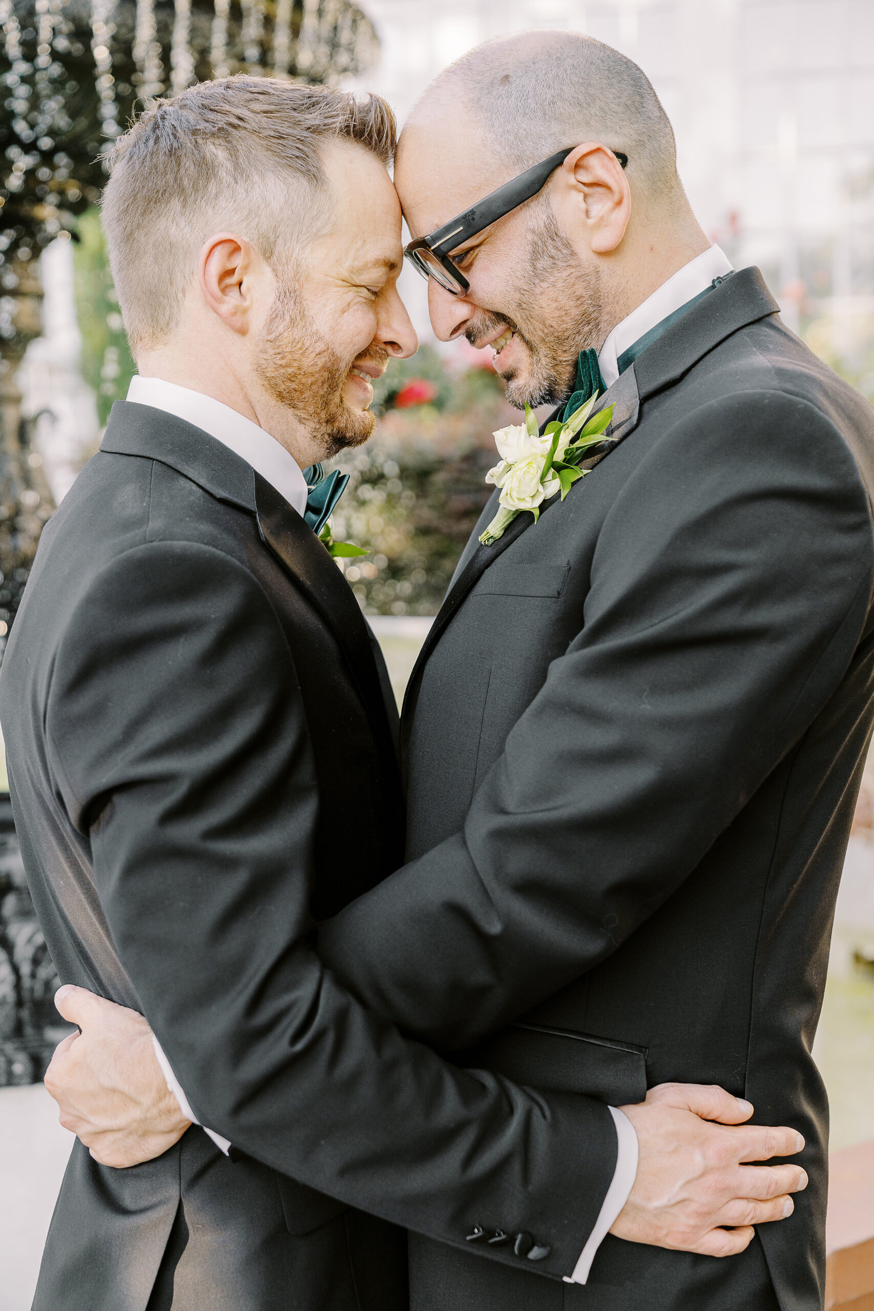 two grooms rest their foreheads together in front of the fountain at their Downtown Sacramento Vizcaya Wedding 