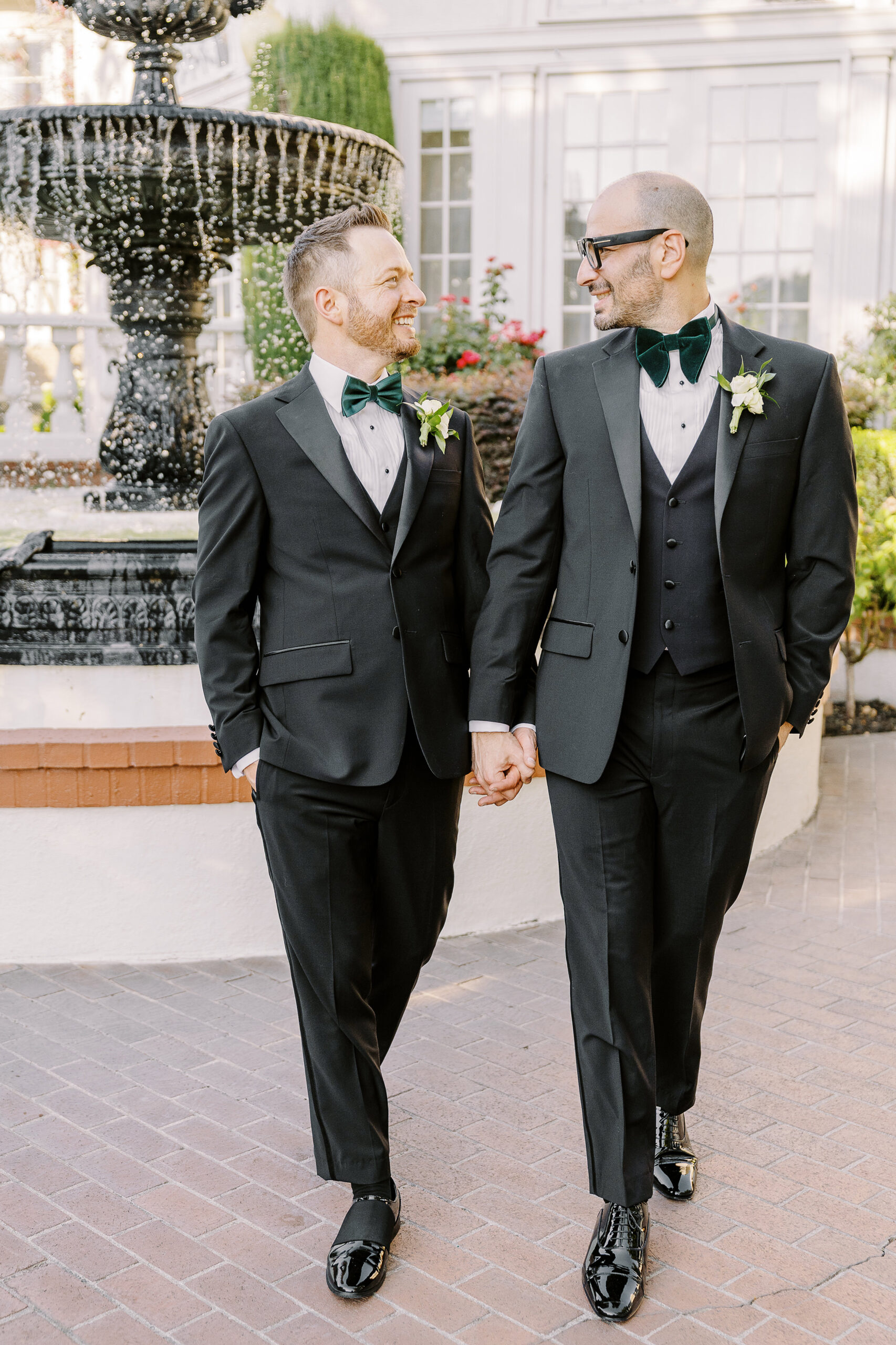 two grooms walk holding hands at their Downtown Sacramento Vizcaya Wedding 