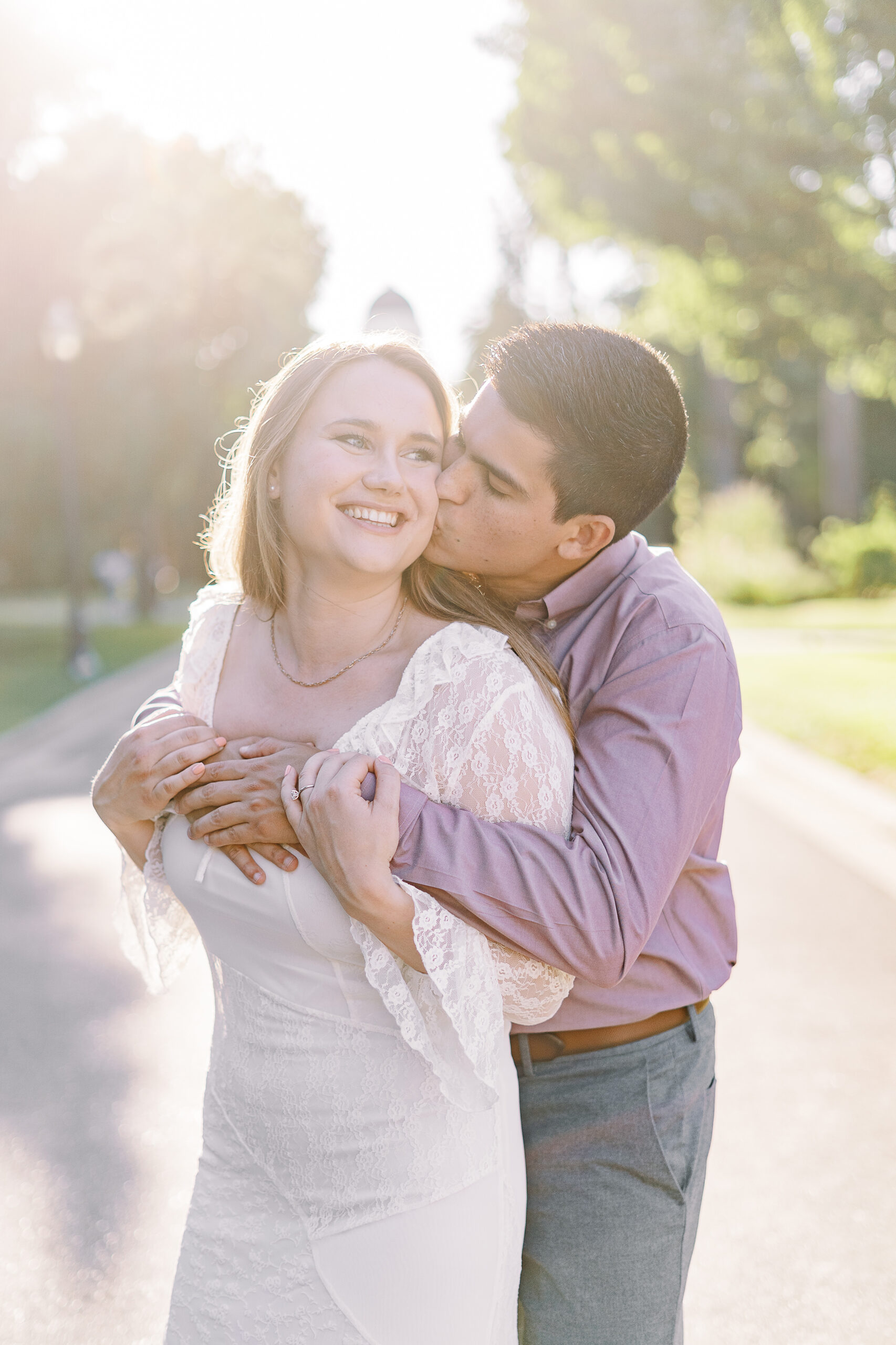 an engaged couple shares a hug in front of the Sacramento Capitol building for their Downtown Sacramento Capitol Engagement 