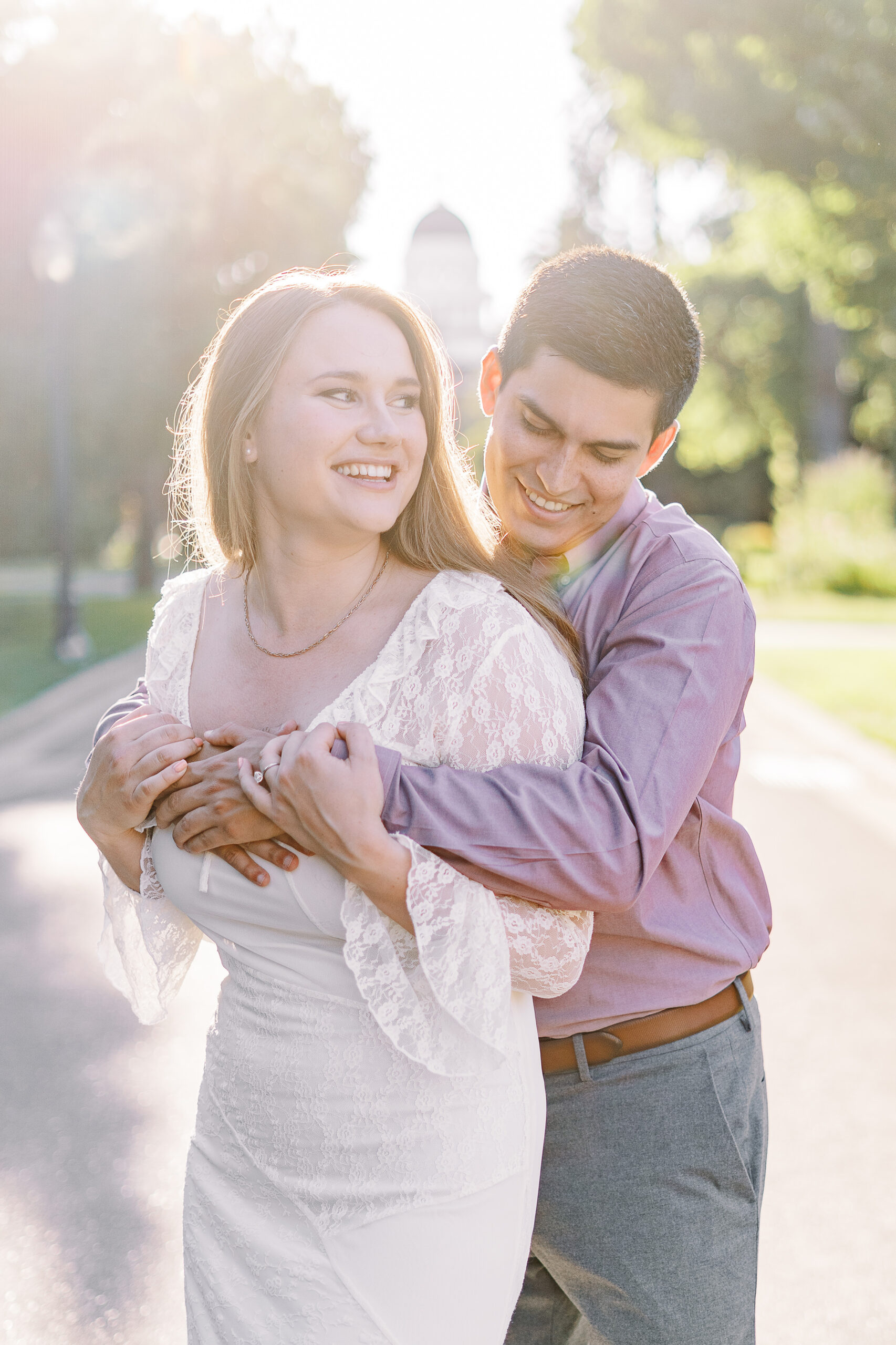 an engaged couple shares a hug in front of the Sacramento Capitol building for their Downtown Sacramento Capitol Engagement 