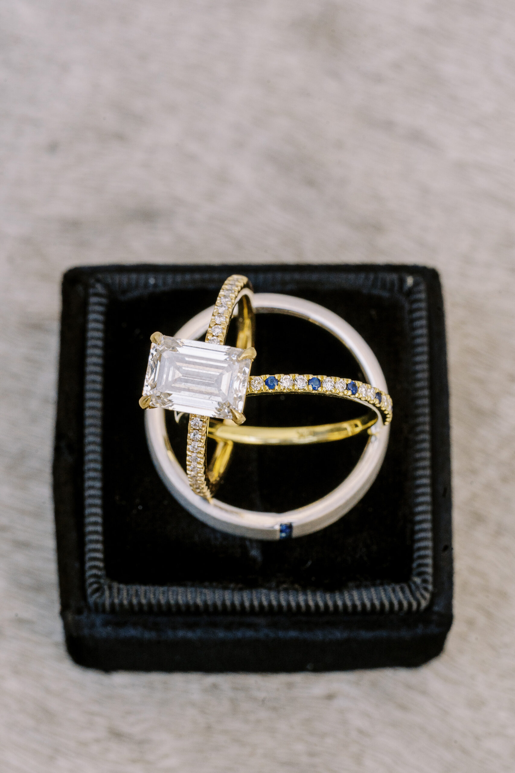 wedding bands and an engagement ring featuring diamonds and sapphires 