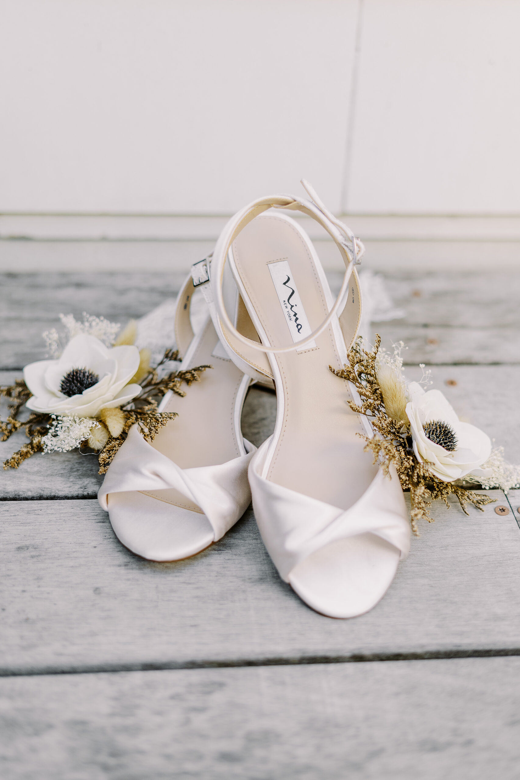 a brides wedding shoes placed on a wood floor