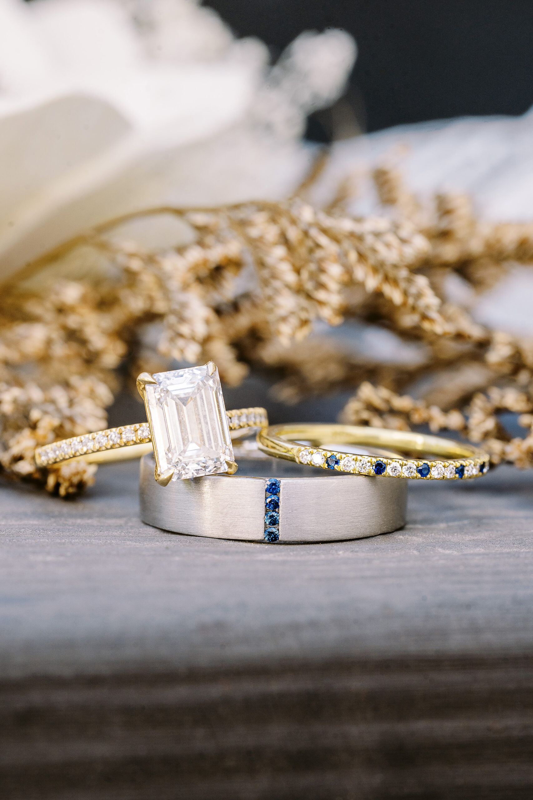 wedding bands and an engagement ring featuring diamonds and sapphires 