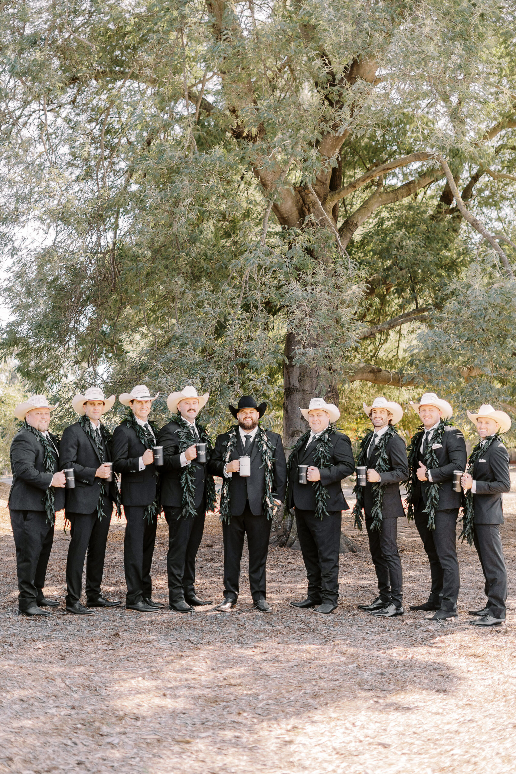 a large 18 person wedding party featuring black suits and white cowboy hats for the gentlemen for a sonoma winery wedding.
