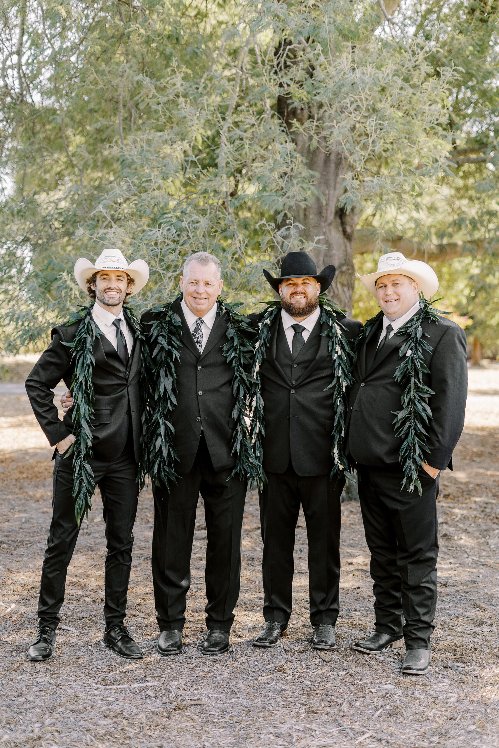 a large 18 persona wedding party featuring black suits and white cowboy hats for the gentlemen for a sonoma winery wedding.