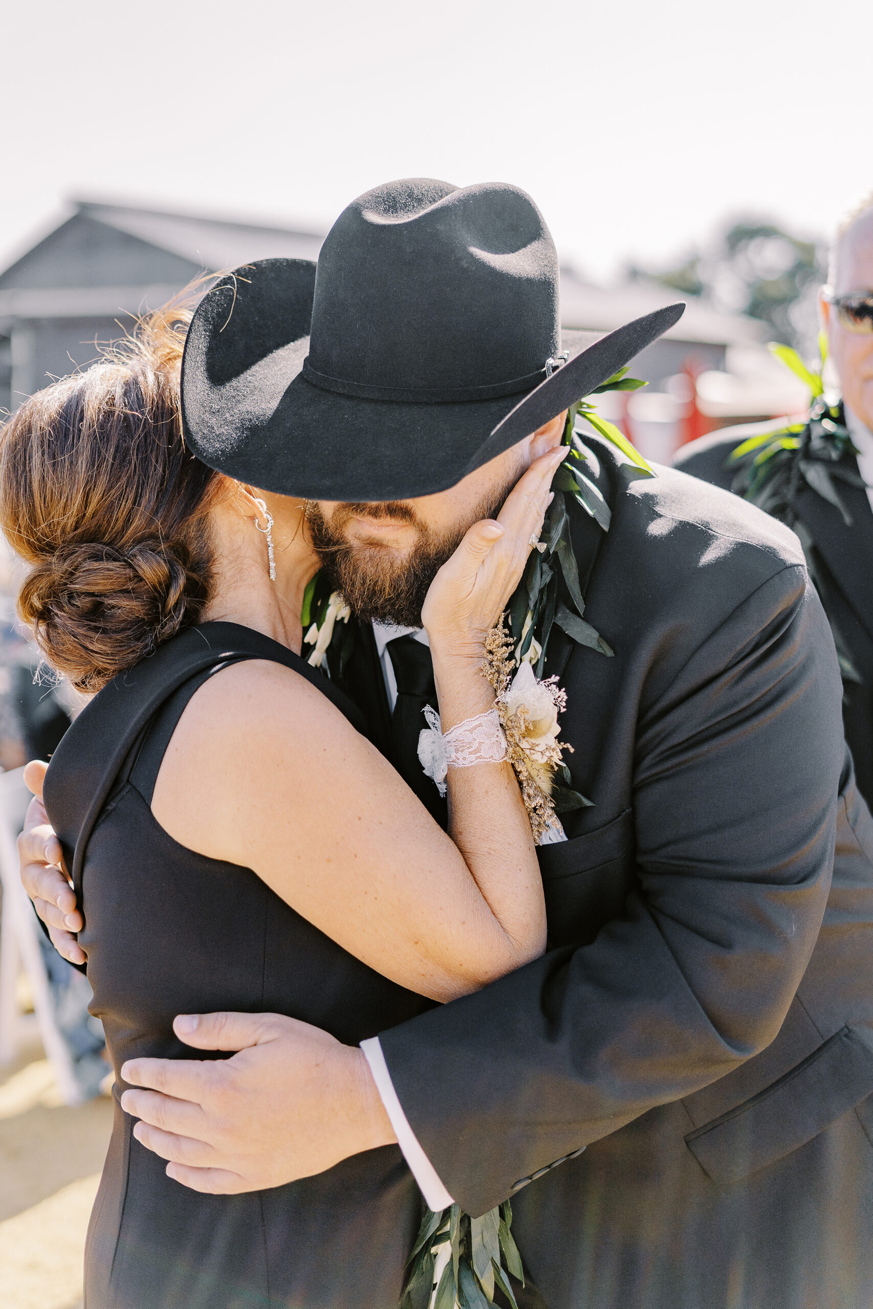 a groom hugs his mother at his Sonoma winery wedding ceremony.