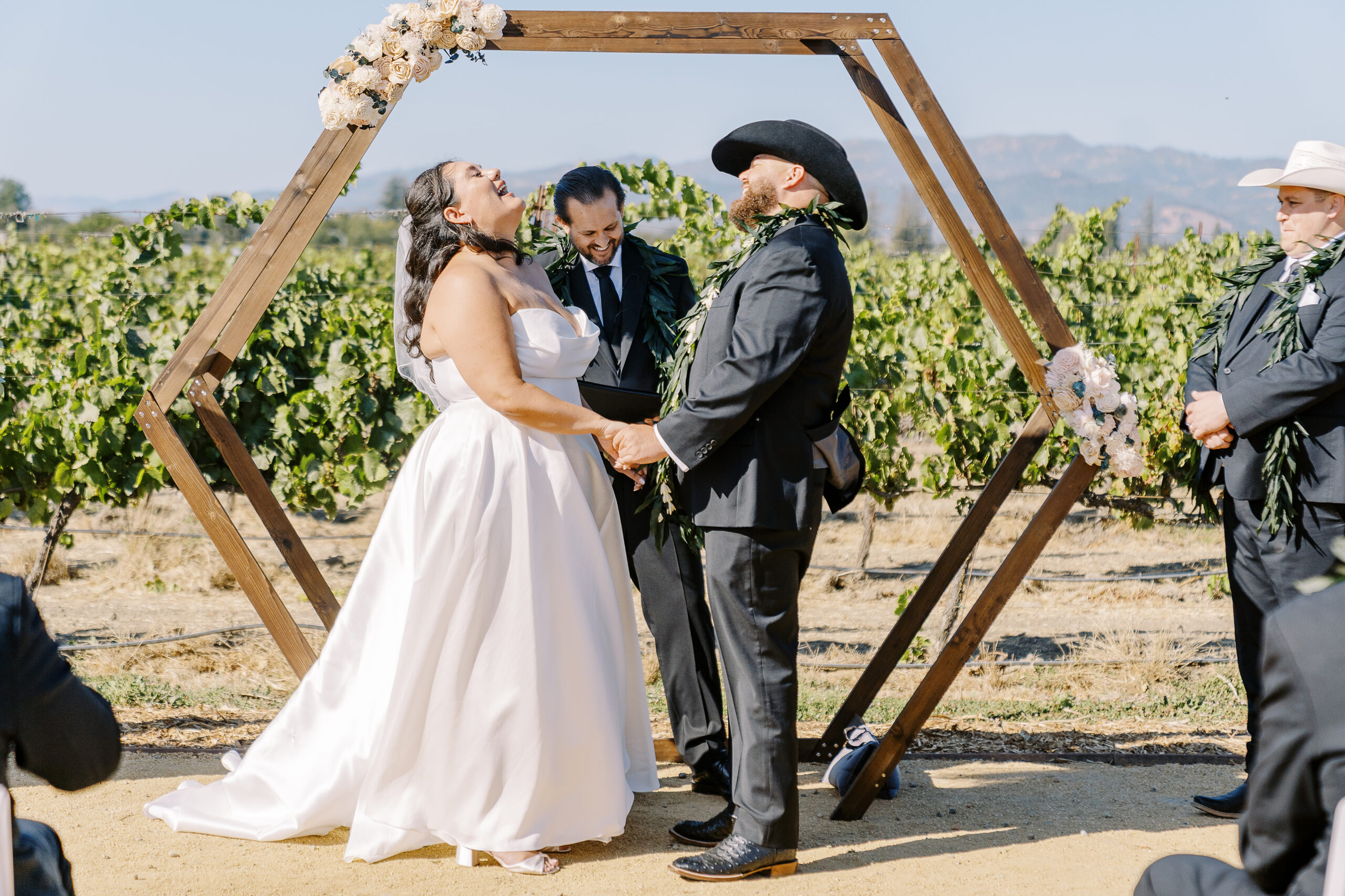 a bride and groom share a laugh during their wedding ceremony during their sonoma winery wedding.