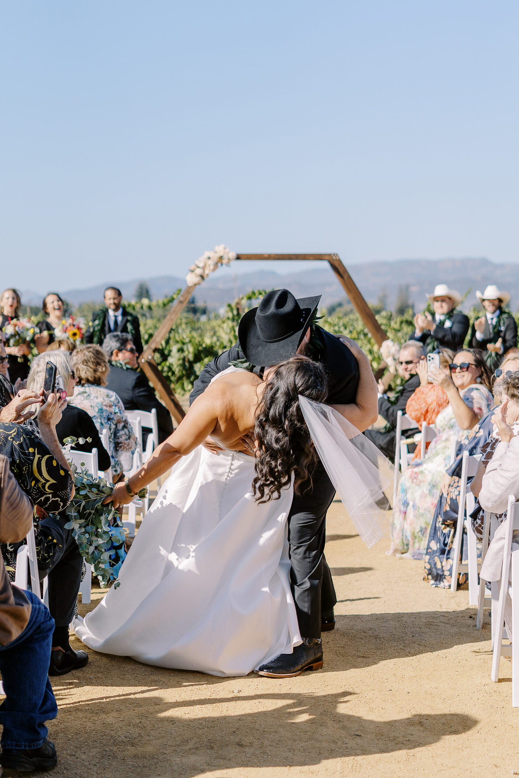 a bride and groom share an aisle kiss during their sonoma winery wedding ceremony