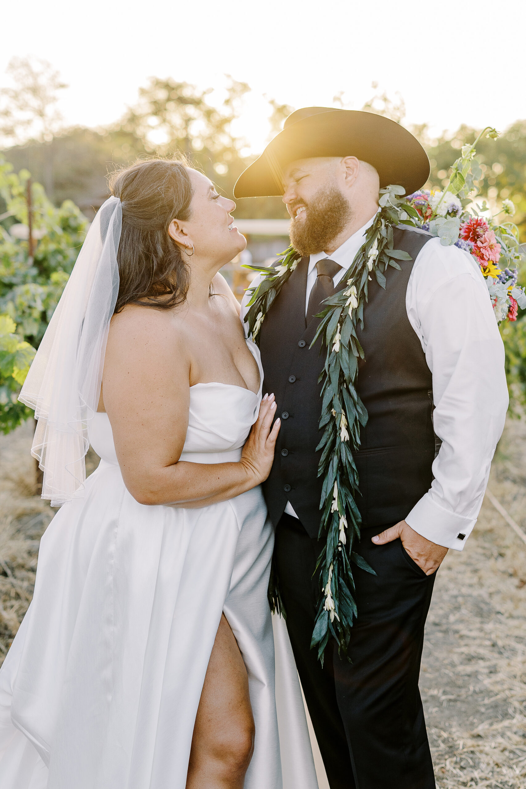 a bride and groom share kisses and pose for portraits at sunset at their sonoma winery wedding.