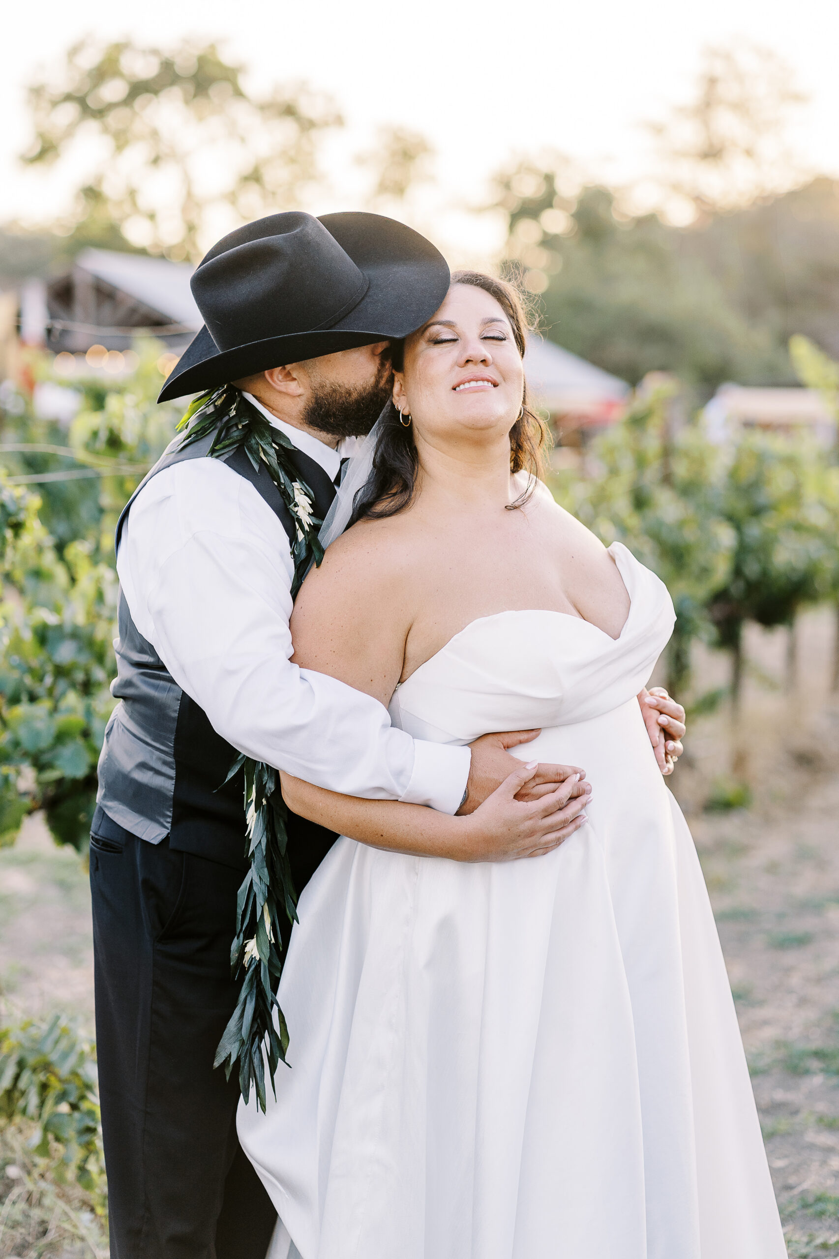 a bride and groom share kisses and pose for portraits at sunset at their sonoma winery wedding.