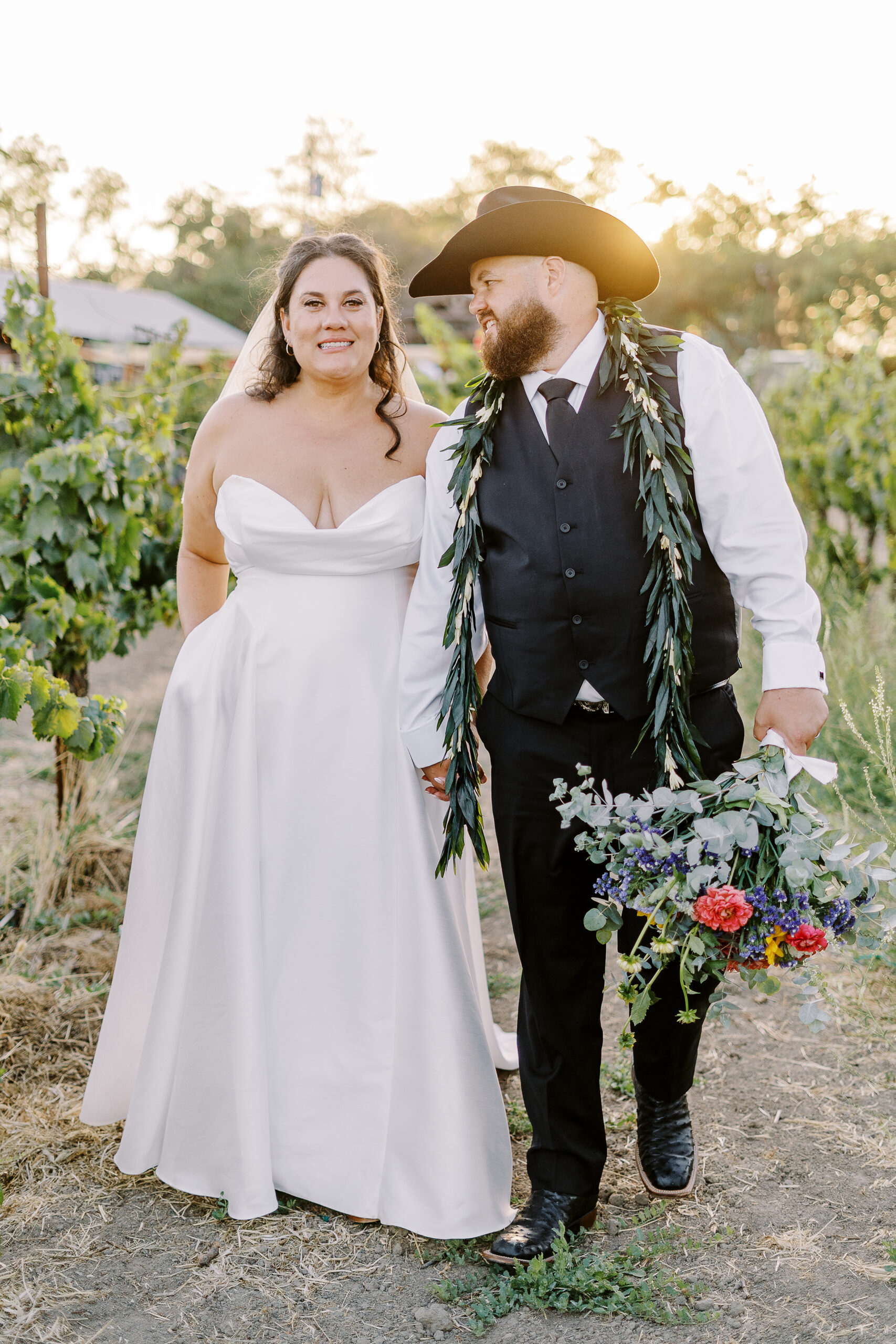 a bride and groom share kisses and pose for portraits at sunset at their sonoma winery wedding.