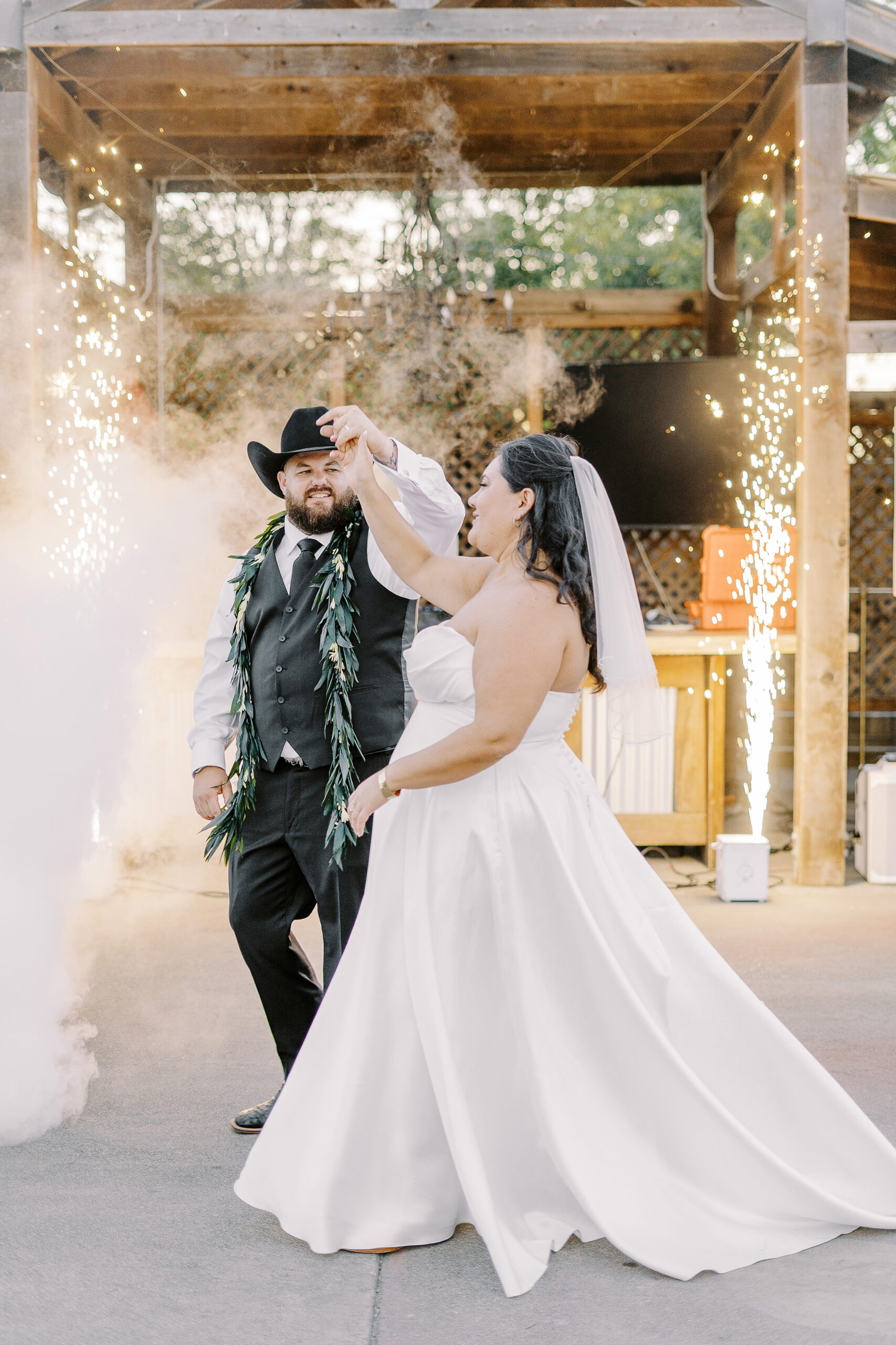 a bride and groom share their first dance with sparklers and a fog machine