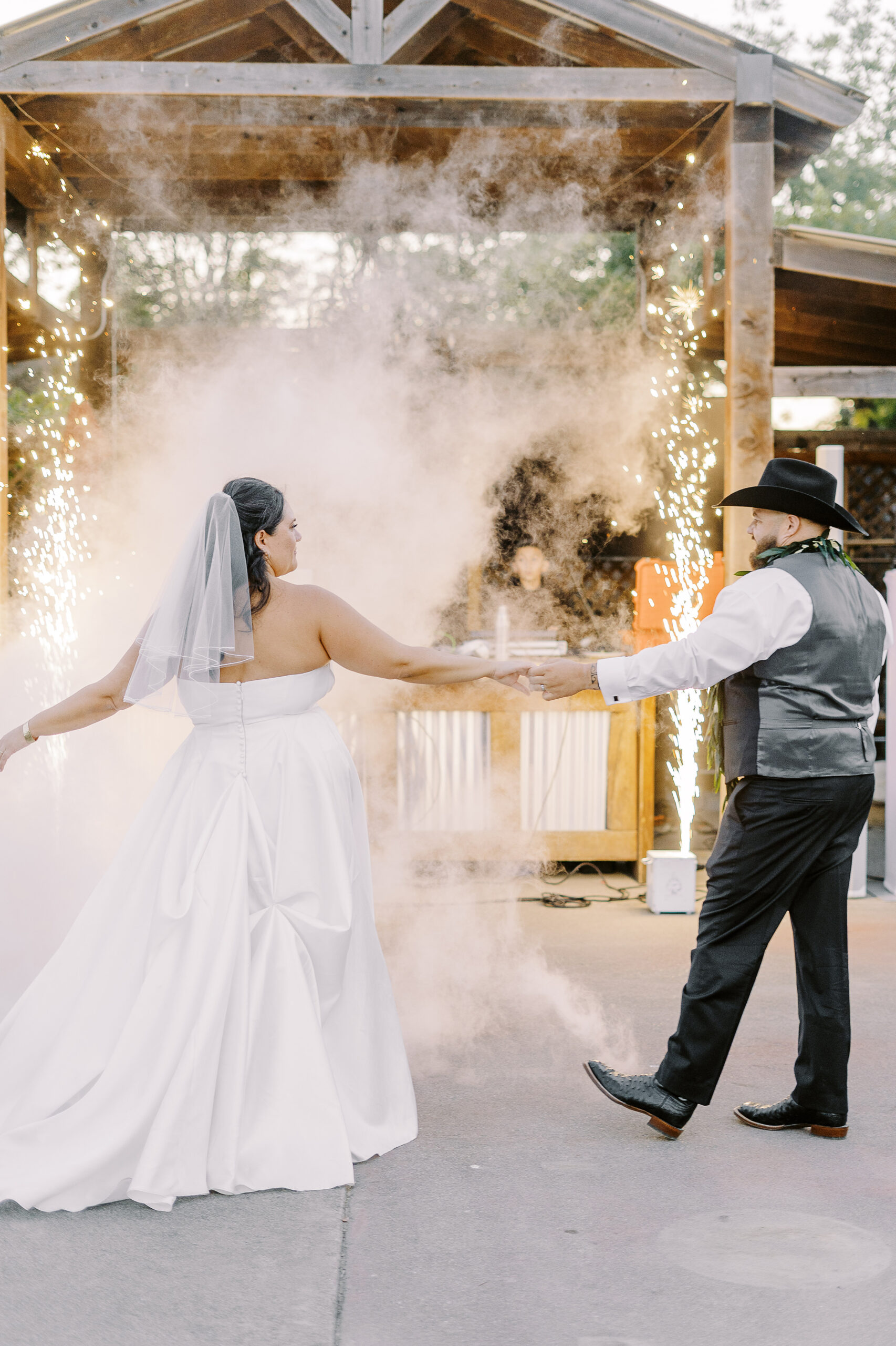 a bride and groom share their first dance with sparklers and a fog machine