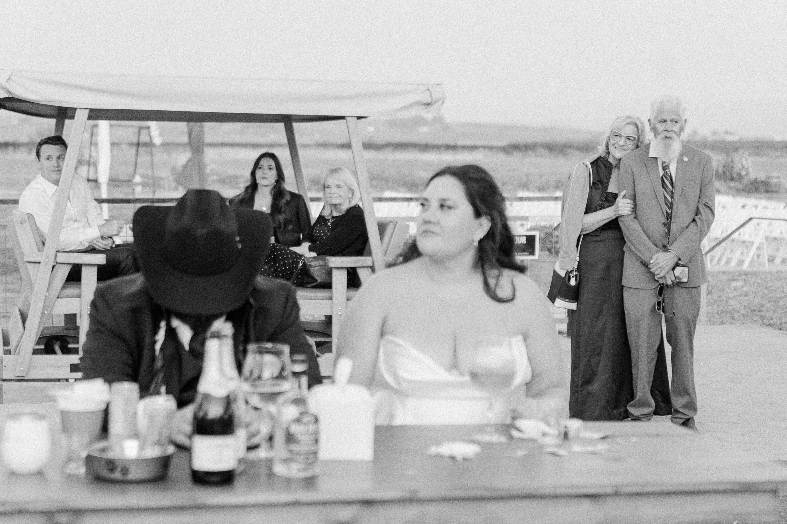 grandparents of the bride and groom watch over the couple as they listen to their reception toasts.